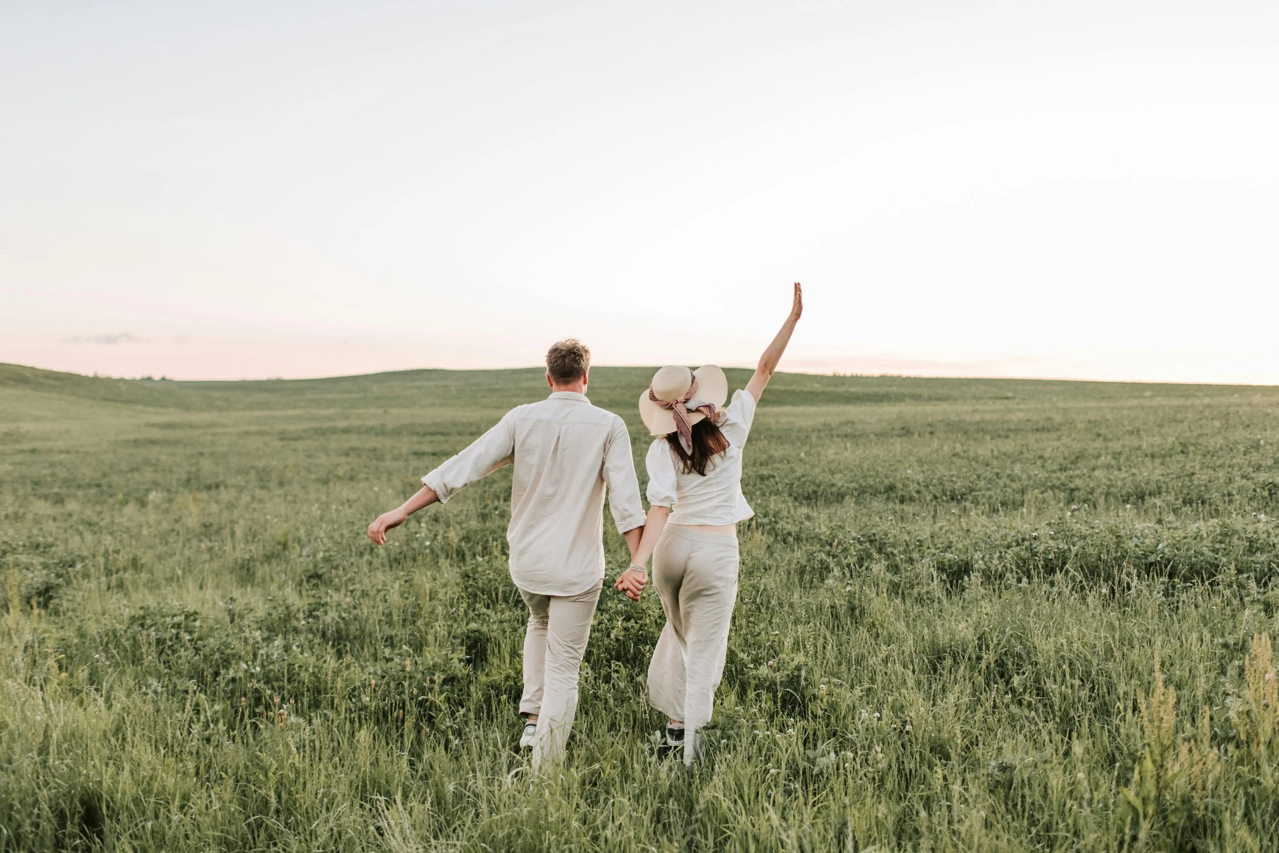 a man and woman walking in a field