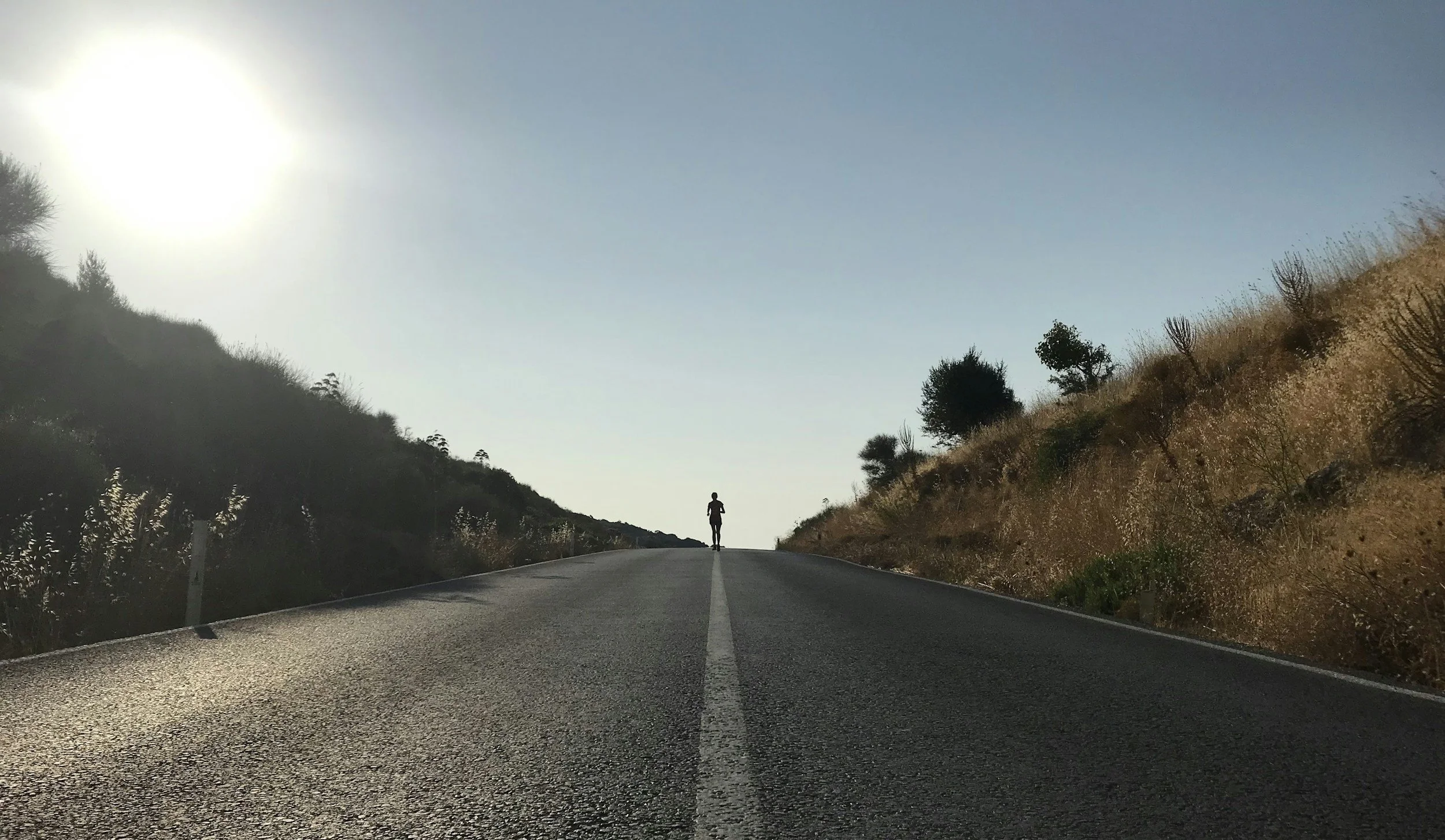 a lone runner on a long country road