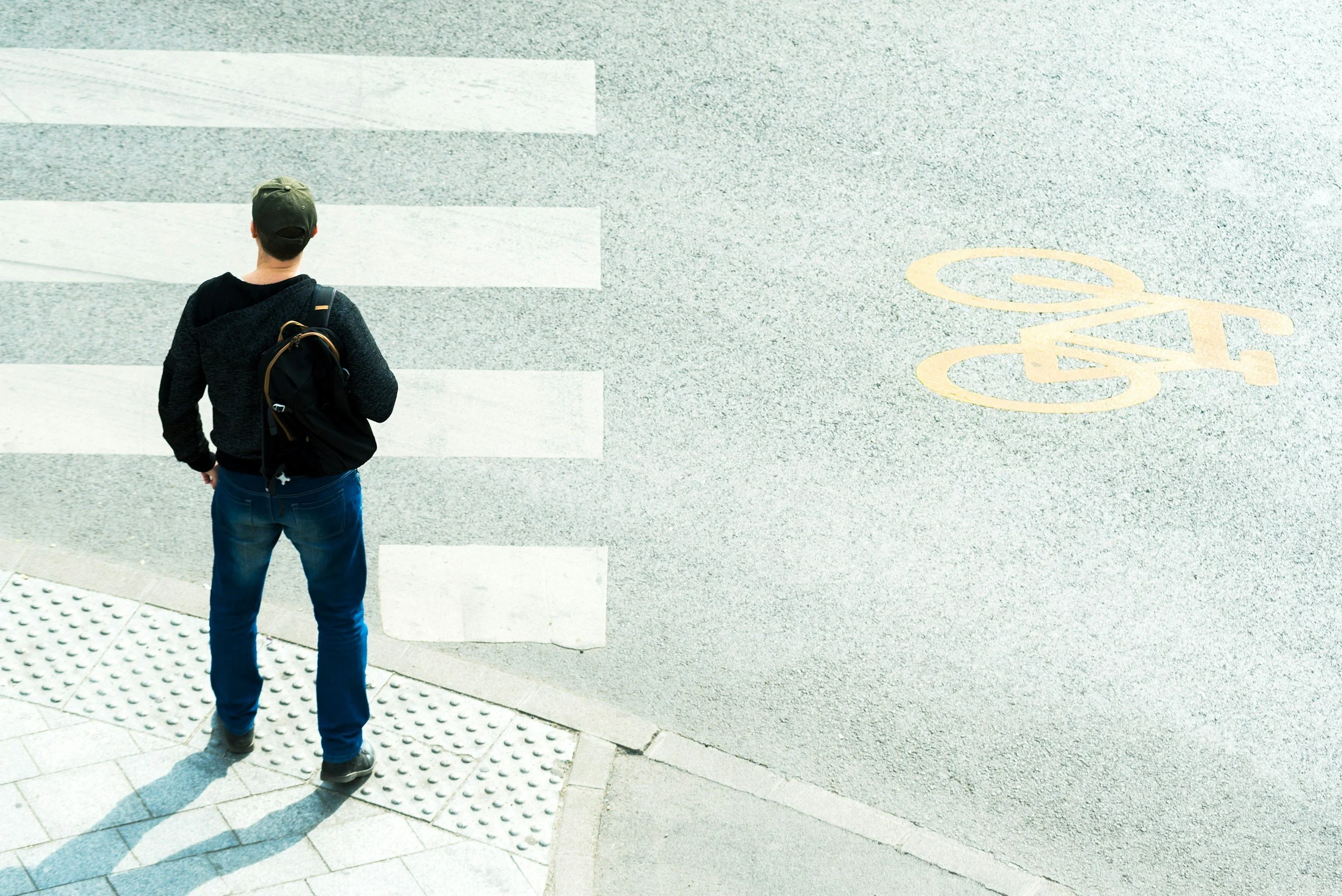 A man deciding to cross at a crosswalk