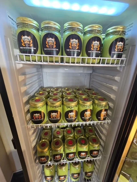 Canned green sauce with a label that features a cartoon chef with a beard, glasses, and a chef's hat, and the text "The Saucesinator."