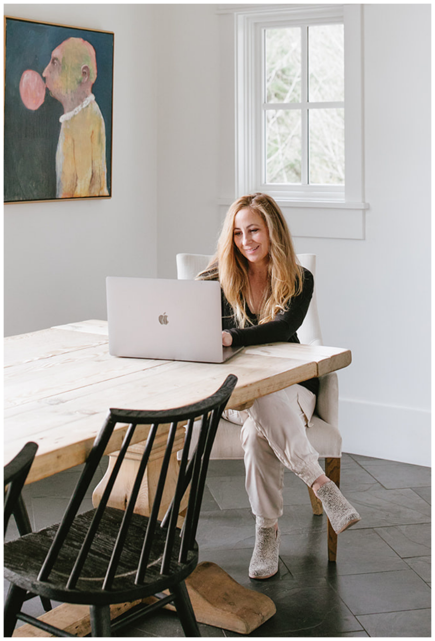Tara Townsend Seattle real estate agent working on laptop at dining table in bright home with natural light and modern interior