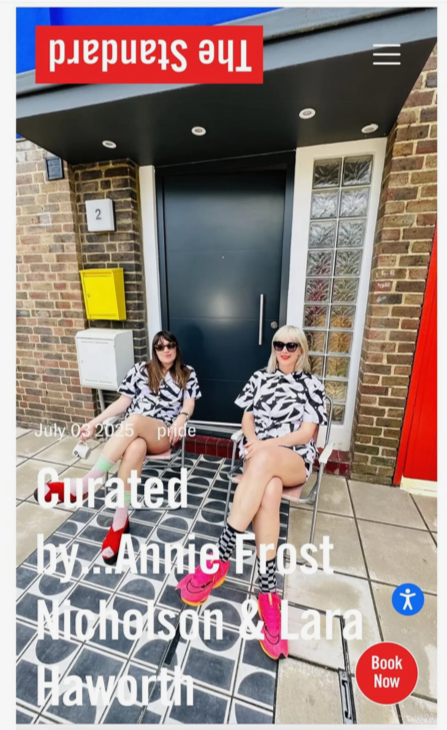 Two women sitting on chairs outside a brick building with a large dark door, glass blocks, a red door, and yellow mailboxes, wearing matching black and white patterned outfits and pink sneakers.