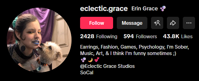 Profile picture of a woman with a dog, smiling and wearing makeup, with a purple background.