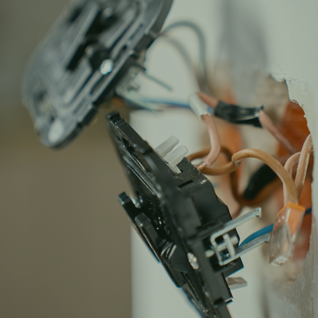 Close-up view of electrical wiring and components inside an electrical outlet.