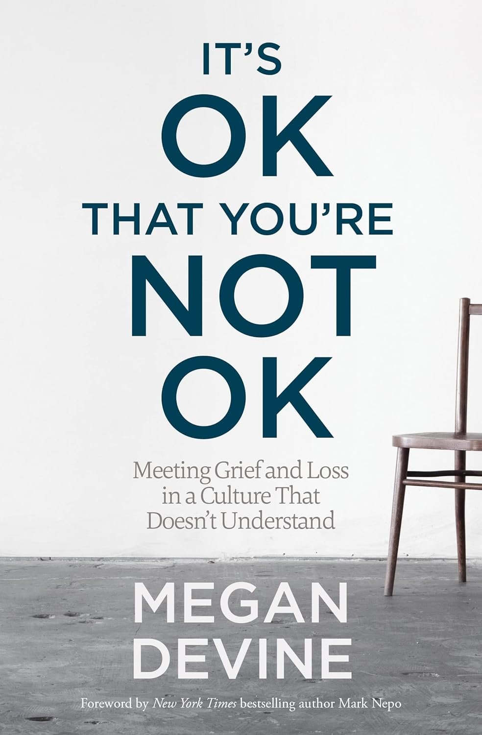 The cover of a book titled 'It's OK That You're Not OK: Meeting Grief and Loss in a Culture That Doesn't Understand' by Megan Devine, featuring a simple room with a wooden chair against a plain wall.