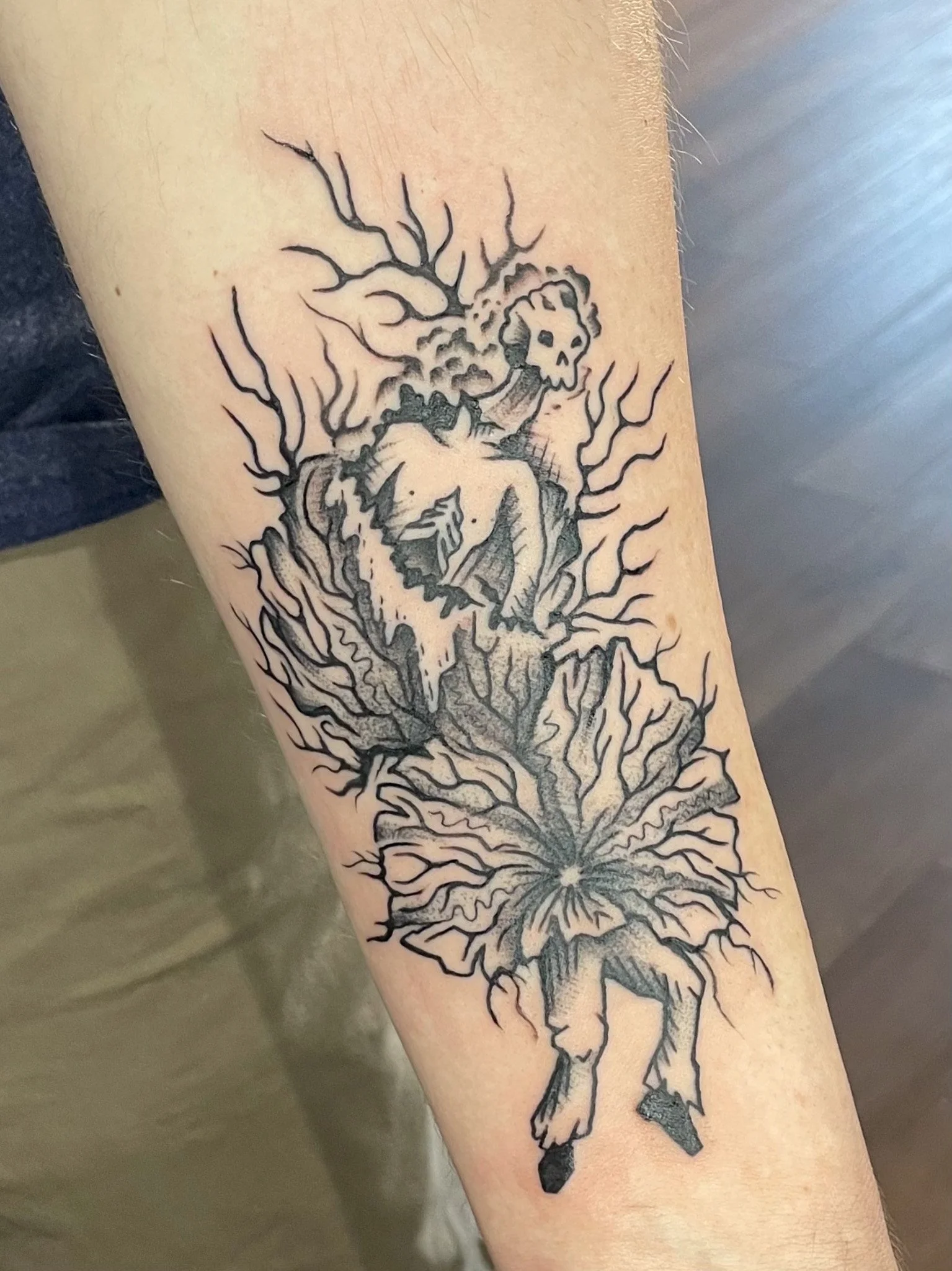 Tattoo of a woman with tree branches and roots extending from her body, with a horse's head at the bottom.