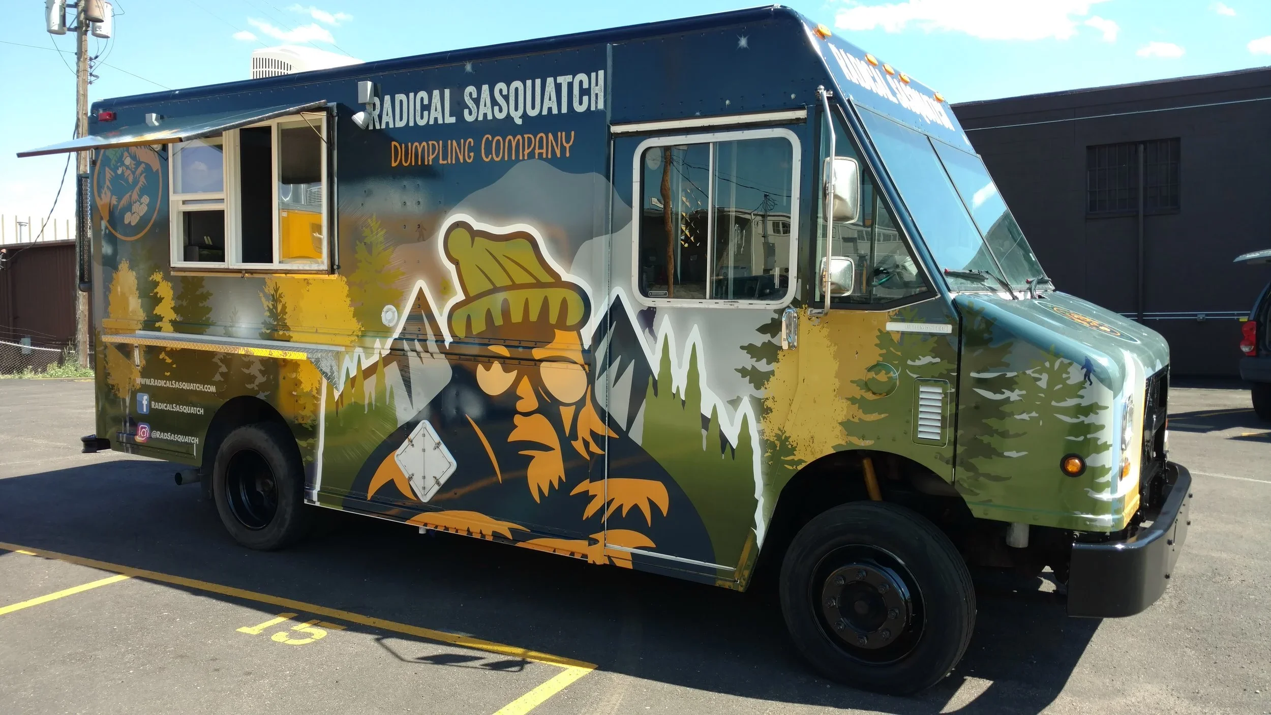 Food truck with colorful outdoor jungle mountain theme and logo of a sasquatch wearing a beanie, labeled Radial Sasquatch Dumpling Company.