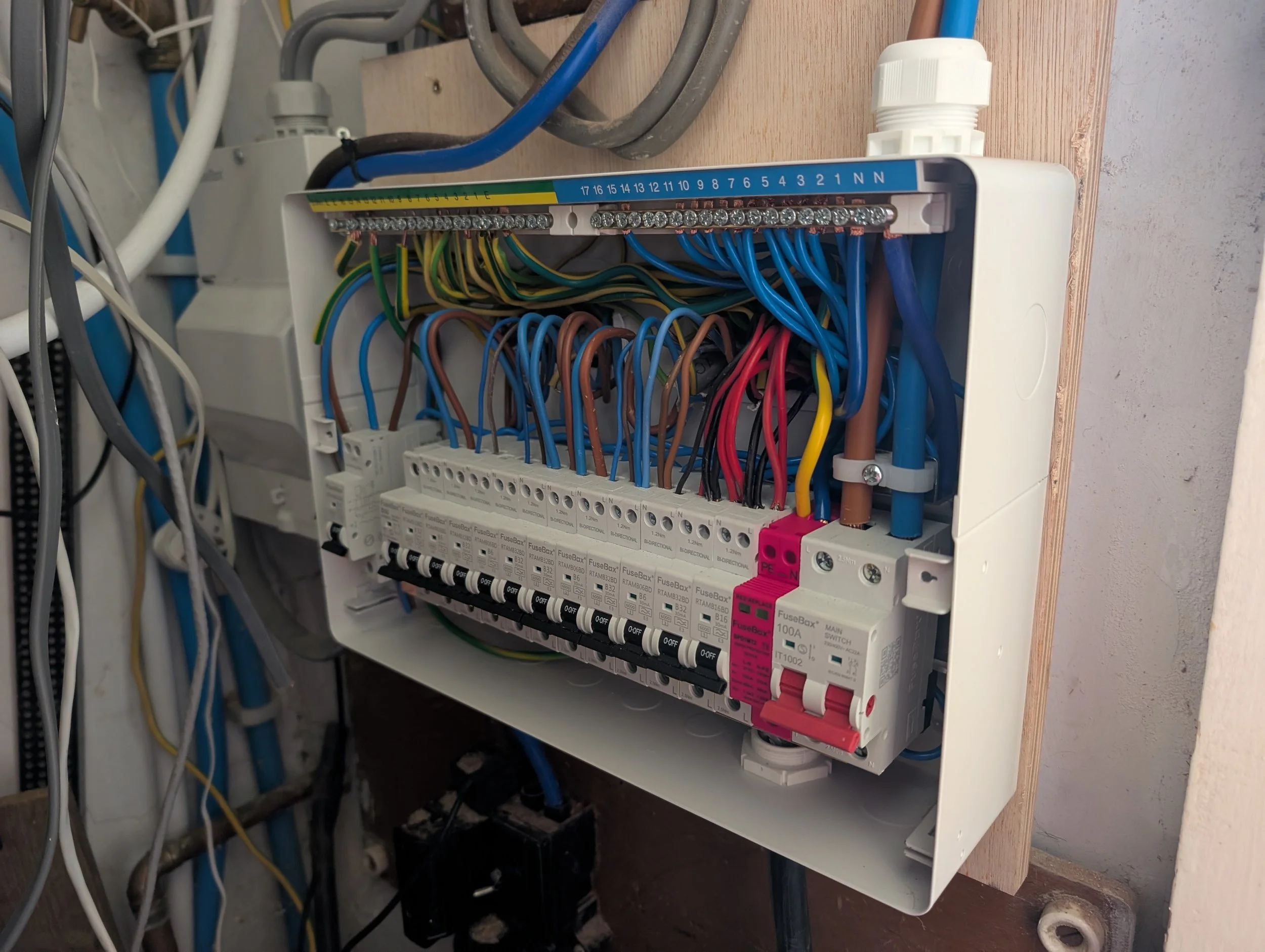 An electrical control panel with various wires and circuit breakers mounted on a wooden board.