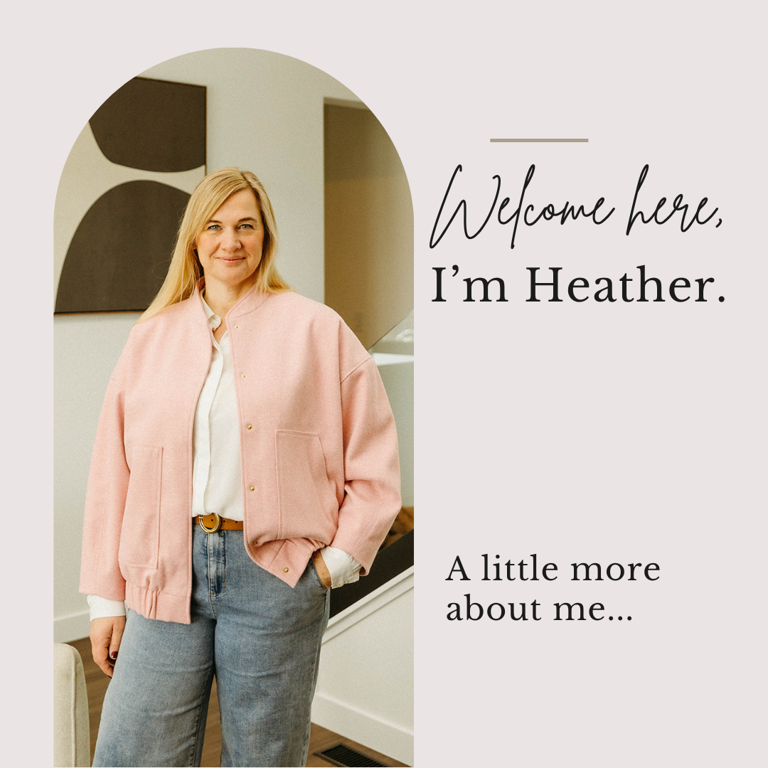 A woman with blonde hair wearing a pink jacket and gray jeans standing inside a modern, well-lit apartment. Text reads "Welcome here, I'm Heather."