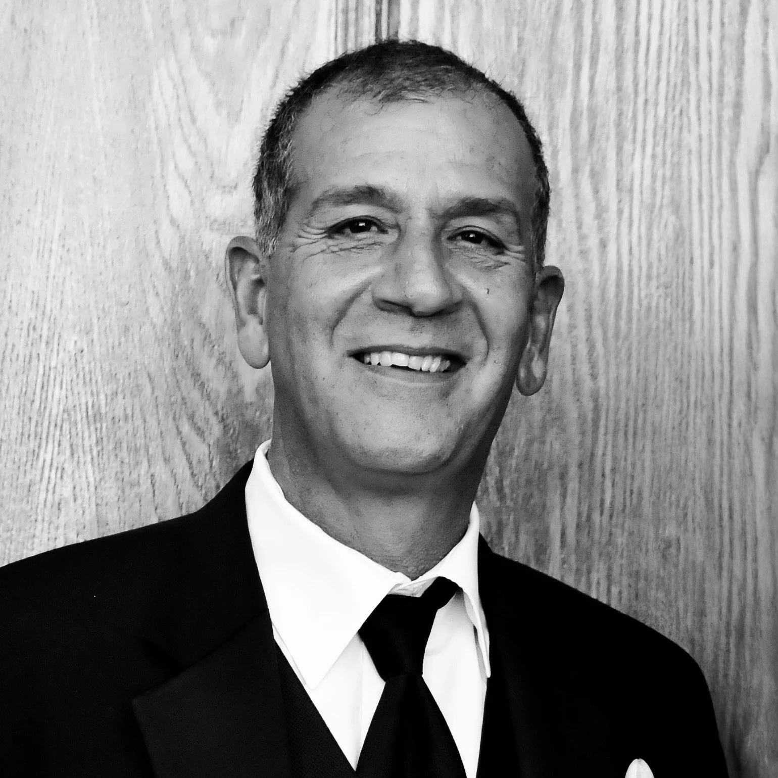 Black and white portrait of Joseph P. Niccoli Sr. in a suit and tie, smiling