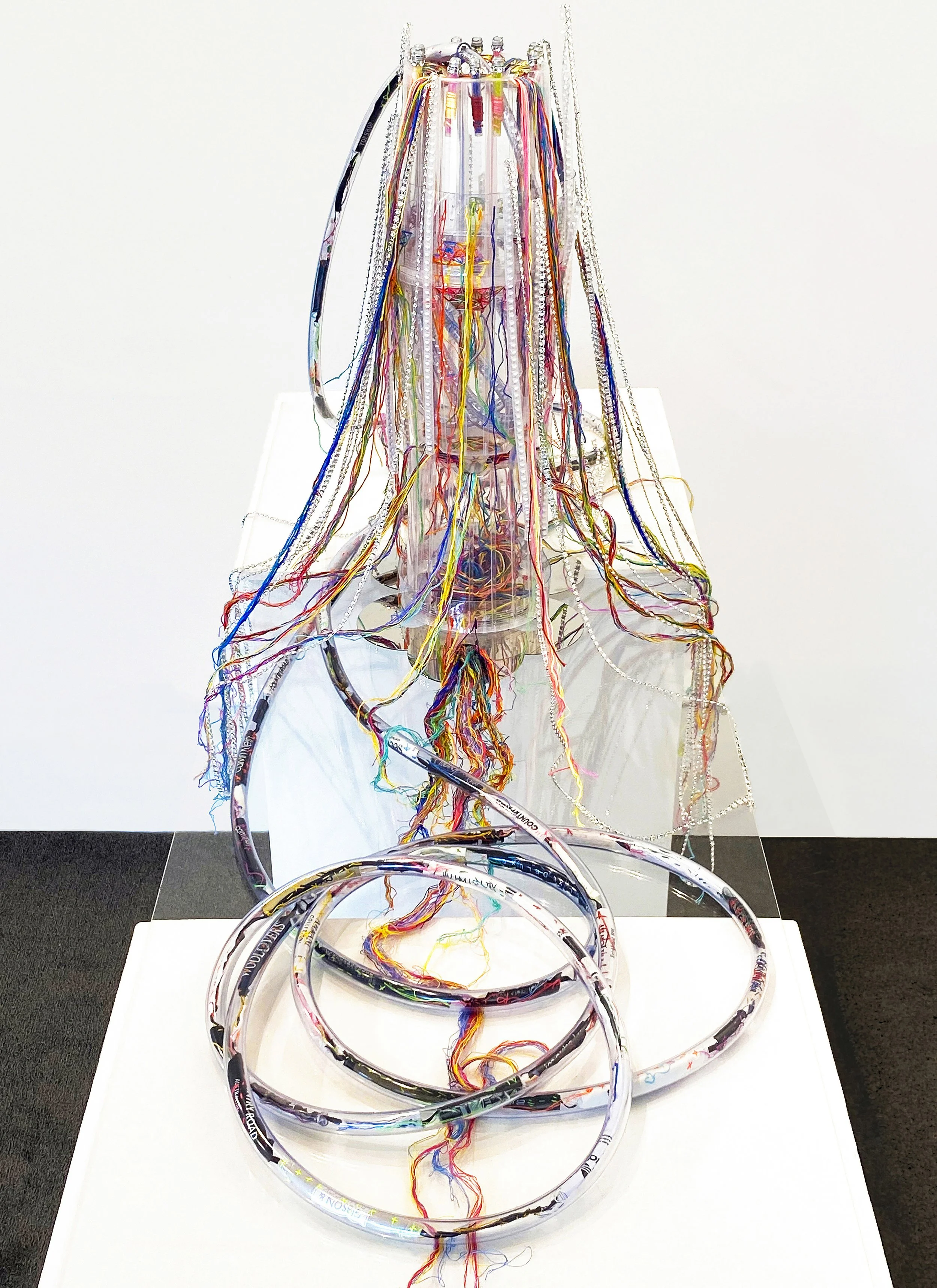 Sculptural techniques contrast linear and circular aspects of the global fashion machine. View of the artwork.