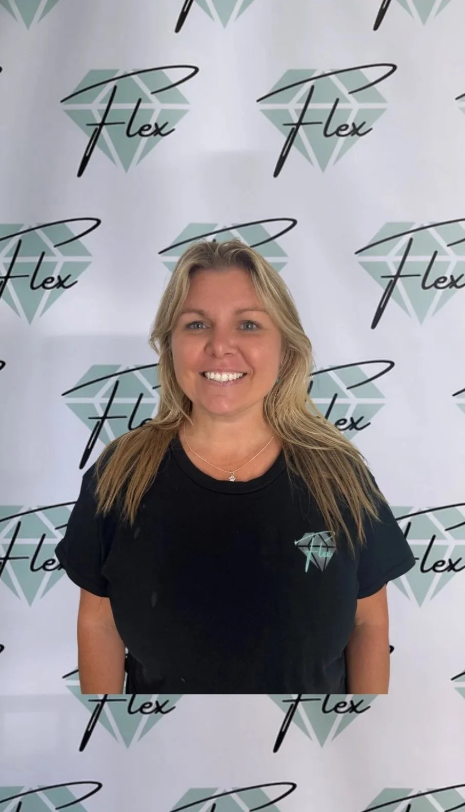 Smiling woman with blonde hair standing in front of a backdrop with the 'Flex' logo and a diamond graphic.