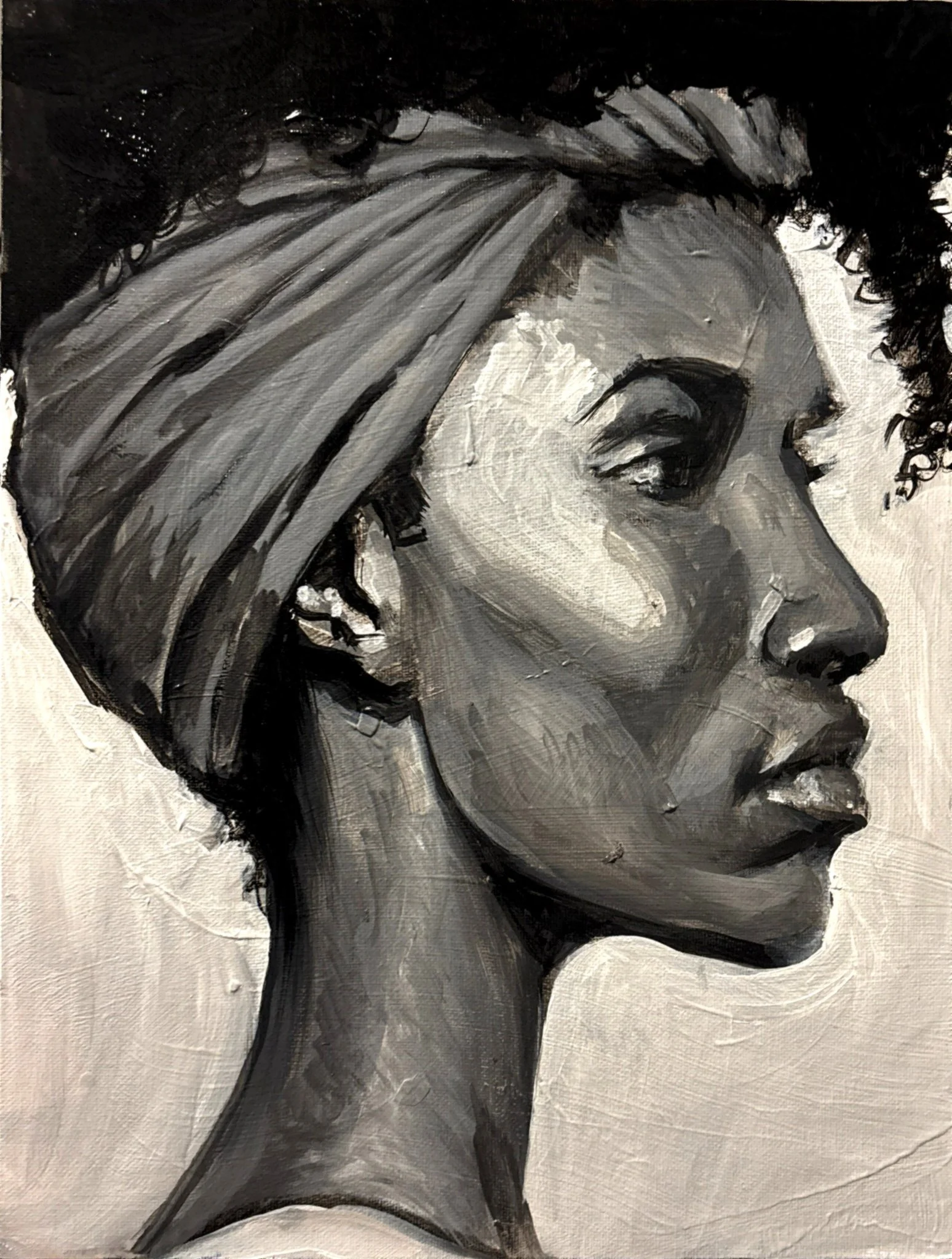 Black and white portrait of a woman in profile with a turban, almond-shaped eyes, full lips, and textured skin.