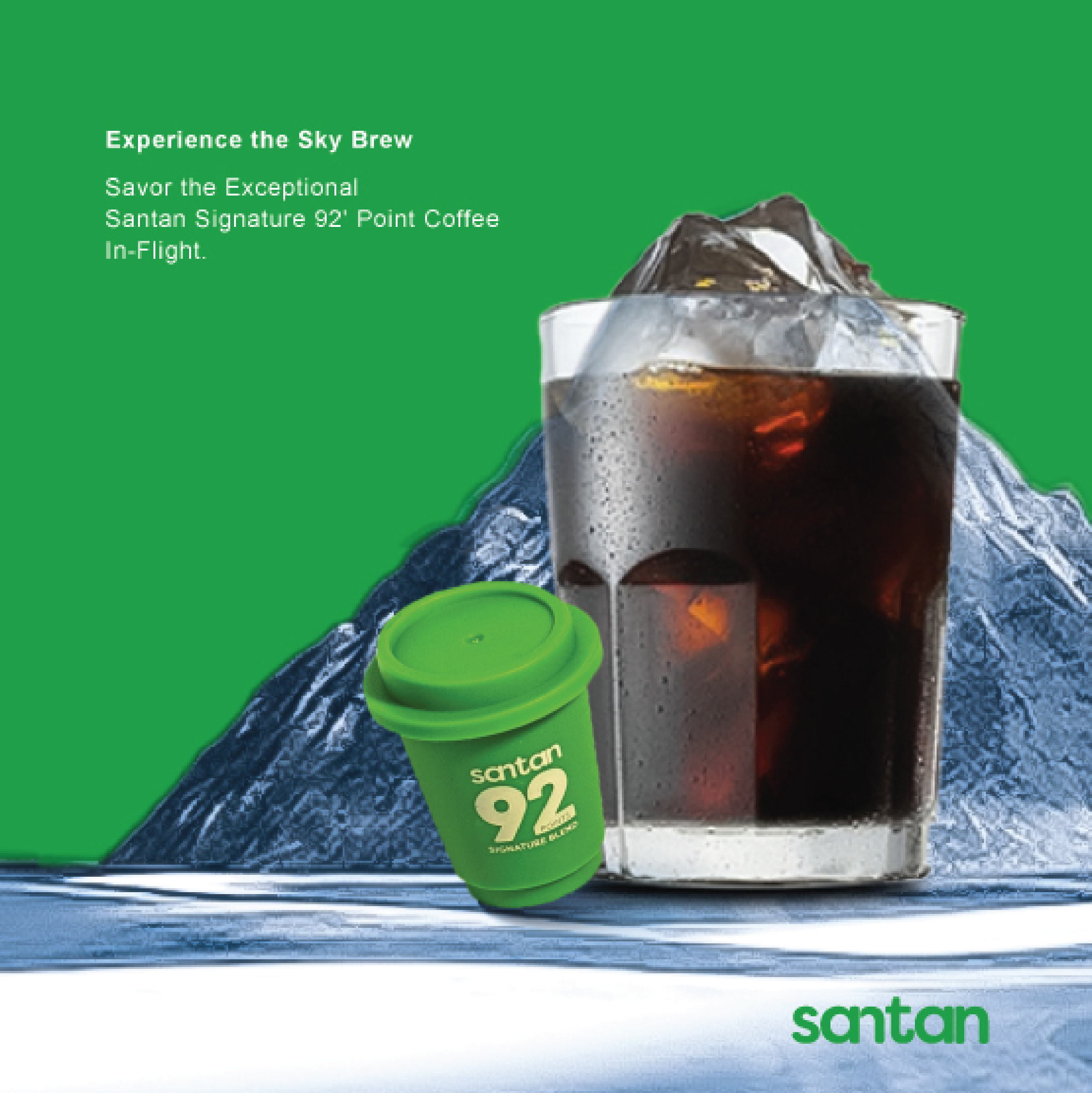 A promotional image for a coffee brand featuring a large glass of iced coffee with ice cubes, a green travel coffee cup with the brand's logo, and a mountain in the background, with promotional text on the left side reading, "Experience the Sky Brew," and describing the coffee as a Santan Signature 92' Point Coffee in-flight.