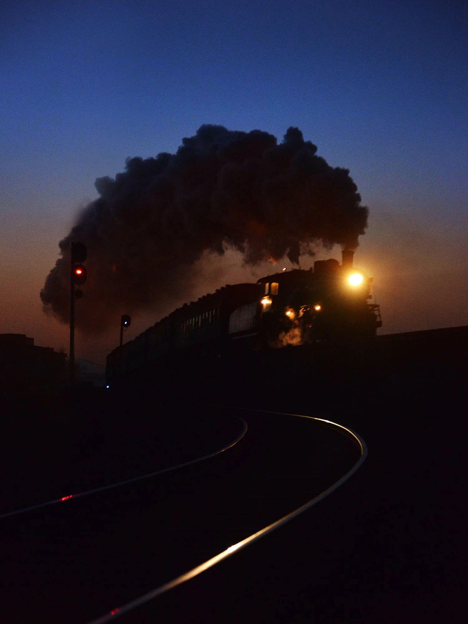  晚間的通勤車從白銀運輸部車站出發，爬上大坡，奔向深部銅礦。2015年11月，這裡的蒸汽機車正式退役。攝於2014年12月。 