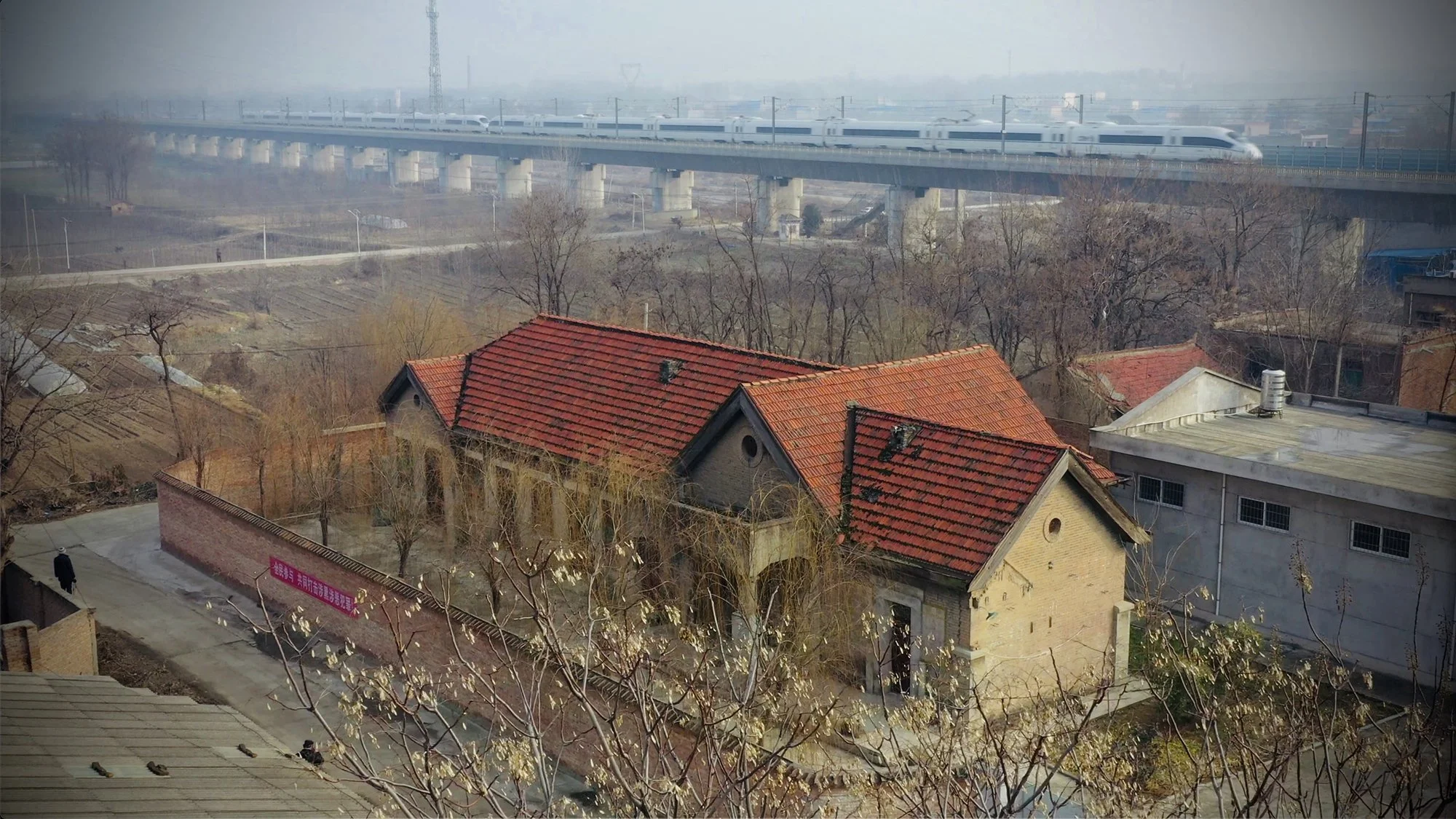  隴海鐵路華州車站建於1934年6月，到1960年，因當局修建三門峽水庫，賀家莊-臨潼段的214公里鐵路被迫改線，華州車站遷至新址。幸運的是，老站房一直留存著，並成為當地文物。圖為華州老站房與2010年通車的鄭州-西安高鐵。攝於2020年1月。 