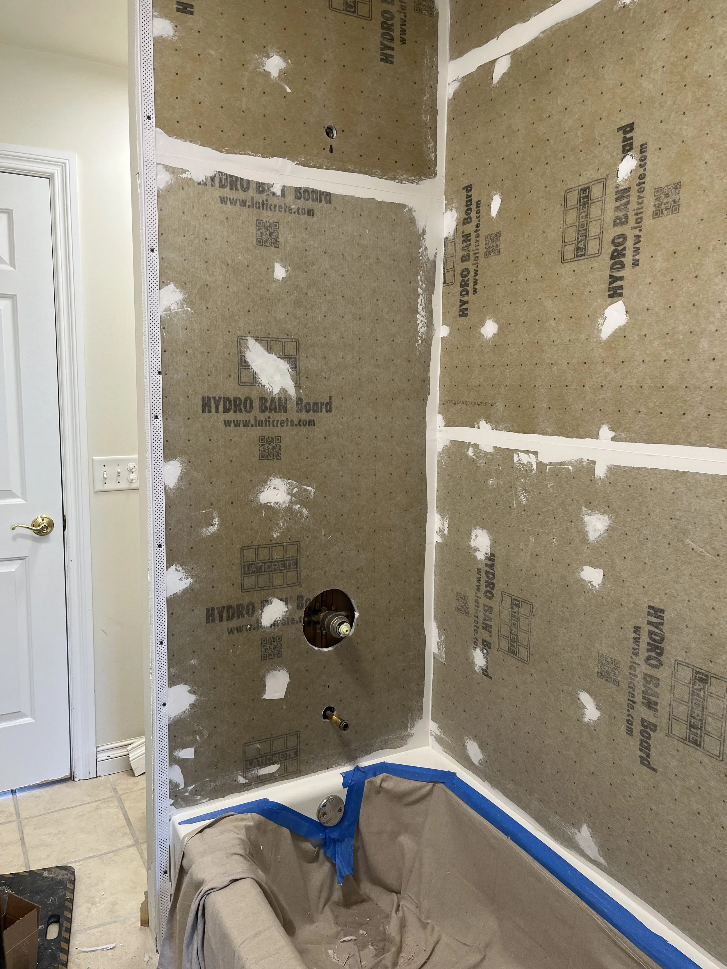 Bathroom under construction with drywall and plumbing fixtures installed, ready for tiling or finishing.