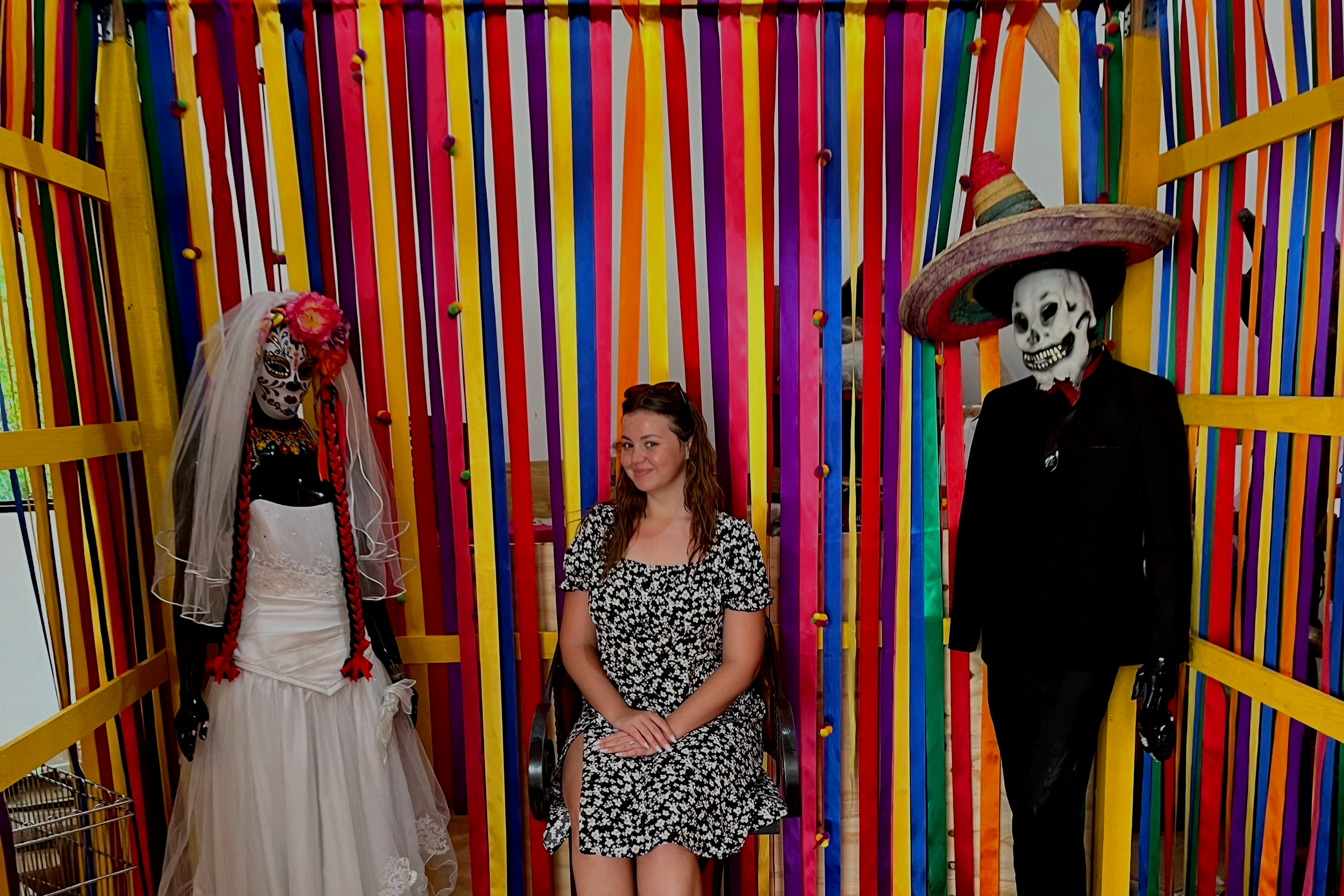 Amanda Lowry Wiberg sitting next to traditional Dia de los Muertos statues