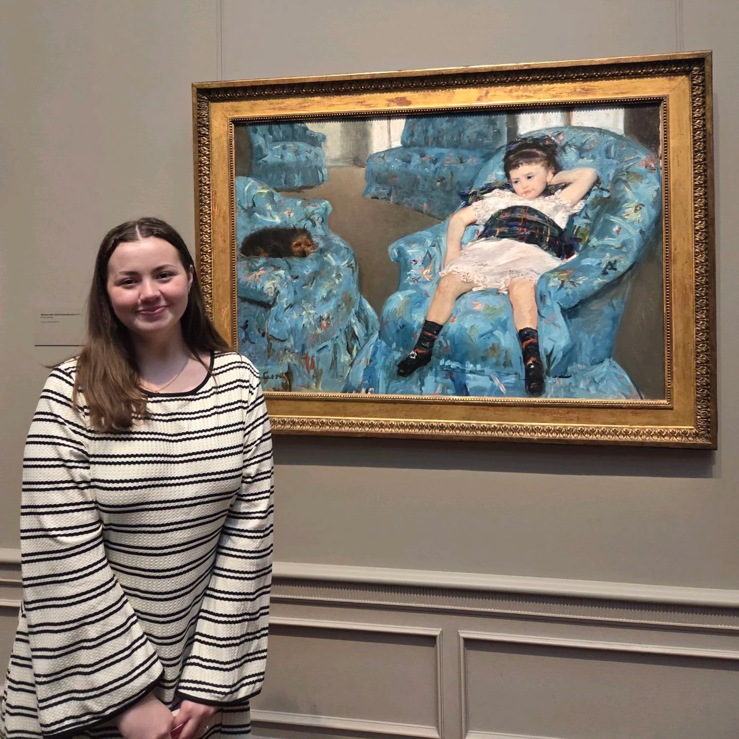 Amanda Lowry Wiberg standing in front of "Girl in a Blue Arm Chair" by Marry Cassatt