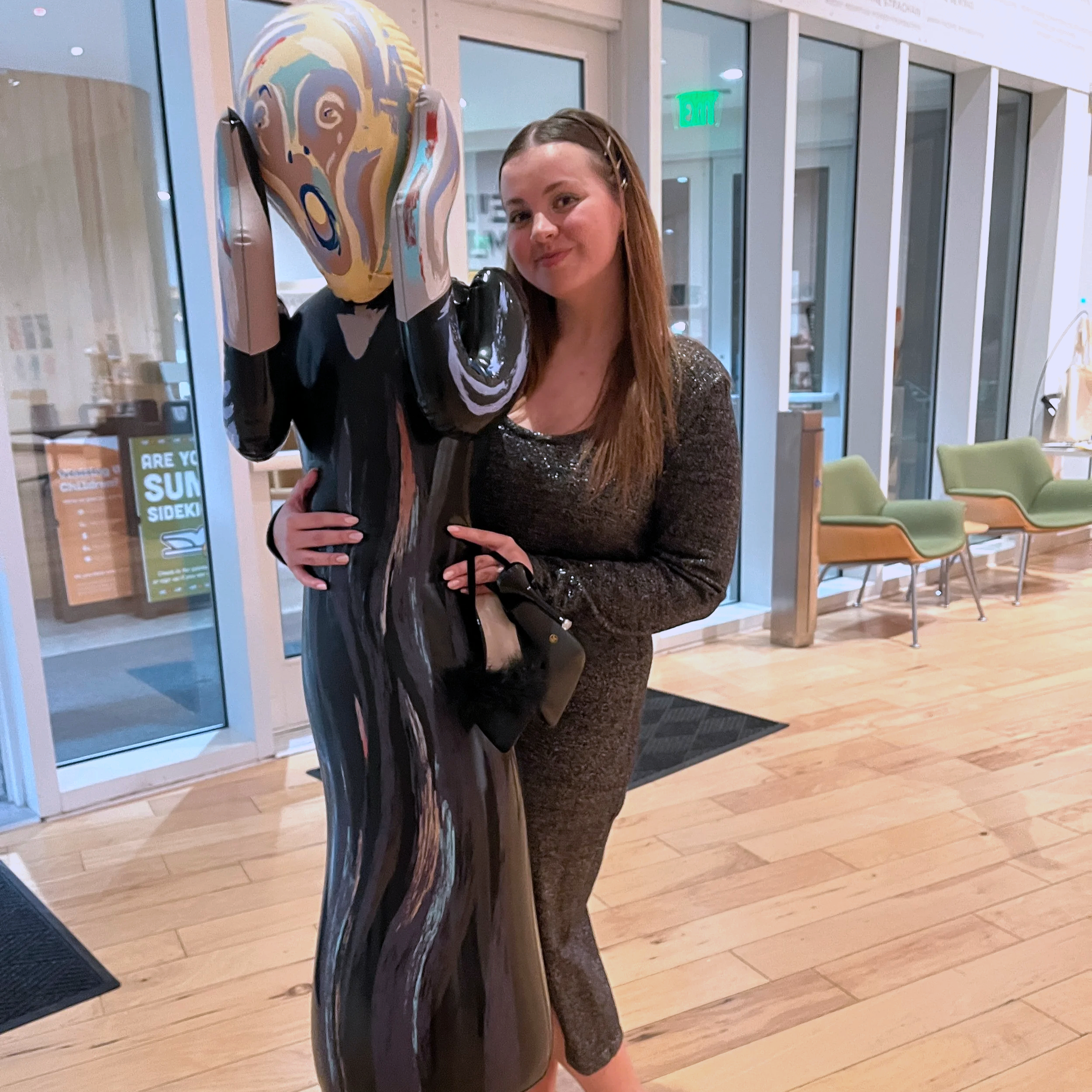 Amanda Lowry Wiberg holding a inflatable doll of the figure from Munch's painting "The Scream"