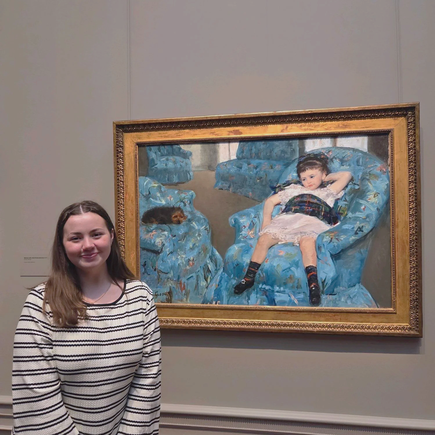 Amanda Lowry Wiberg standing in front of "Girl in a Blue Arm Chair" by Mary Cassatt