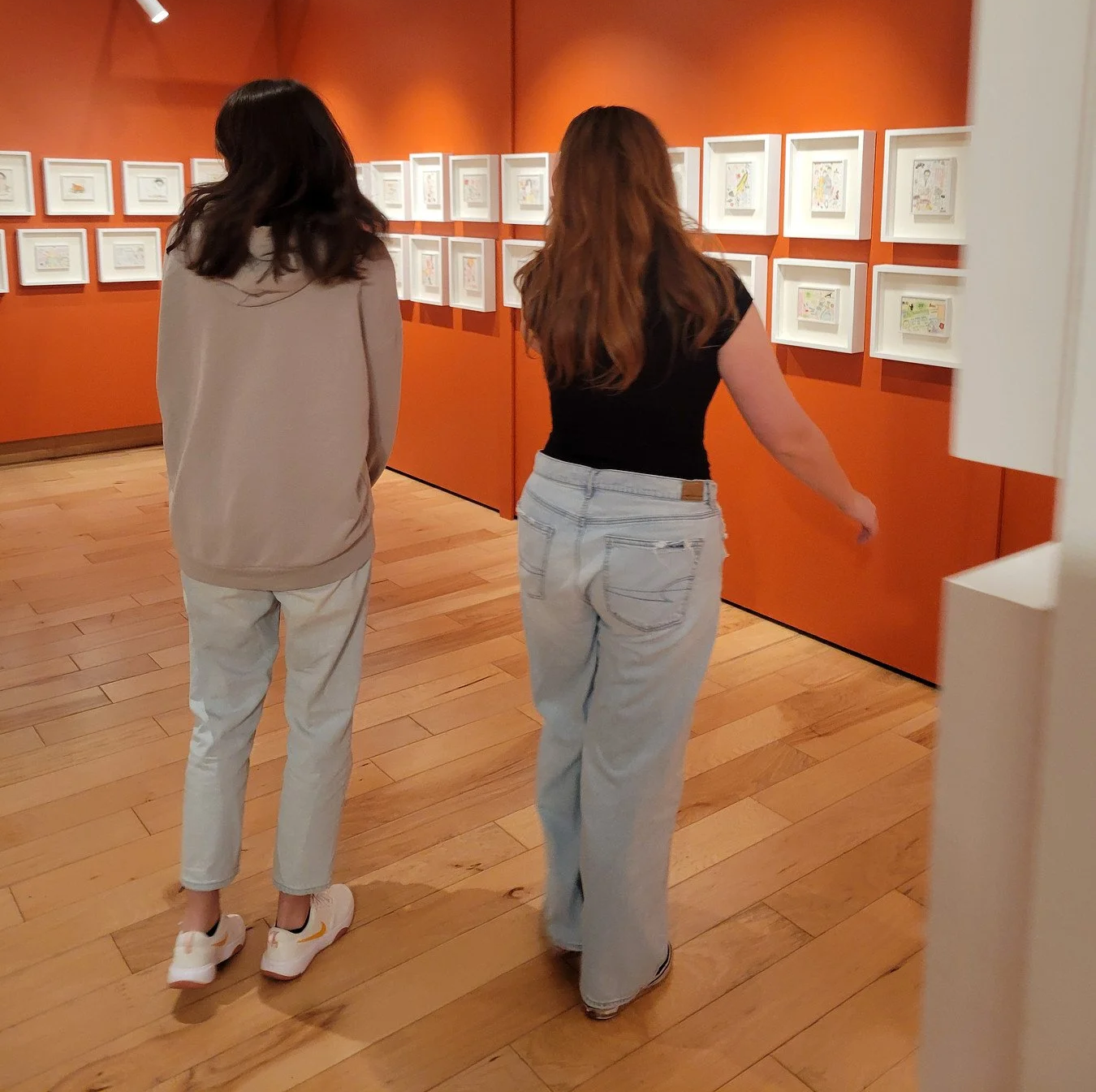 Two girls walking around an art gallery