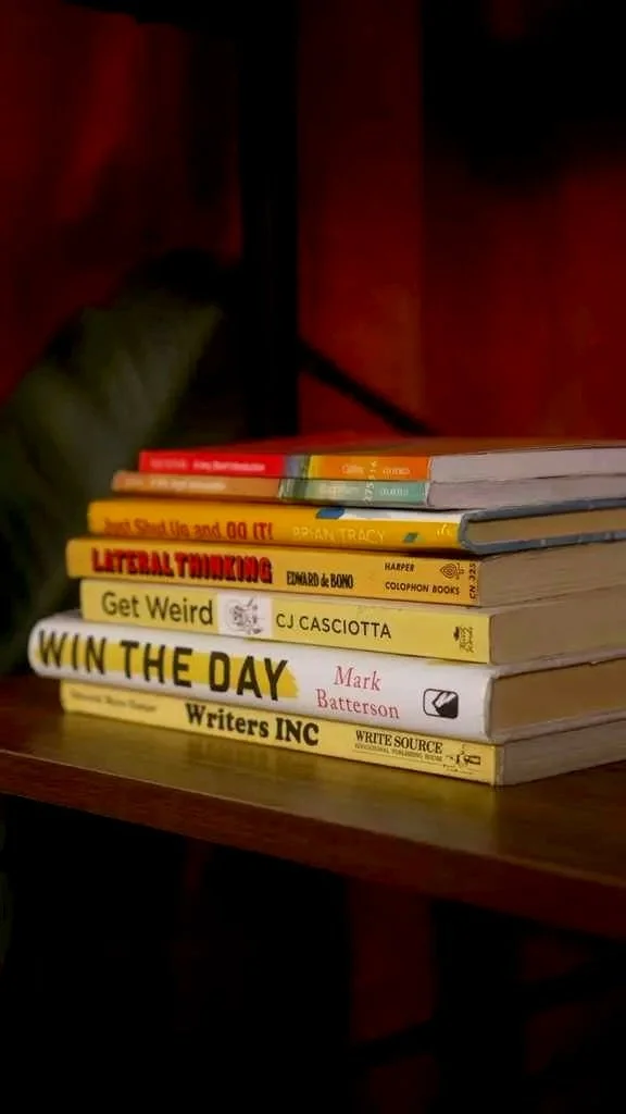 Stack of books on a wooden table.