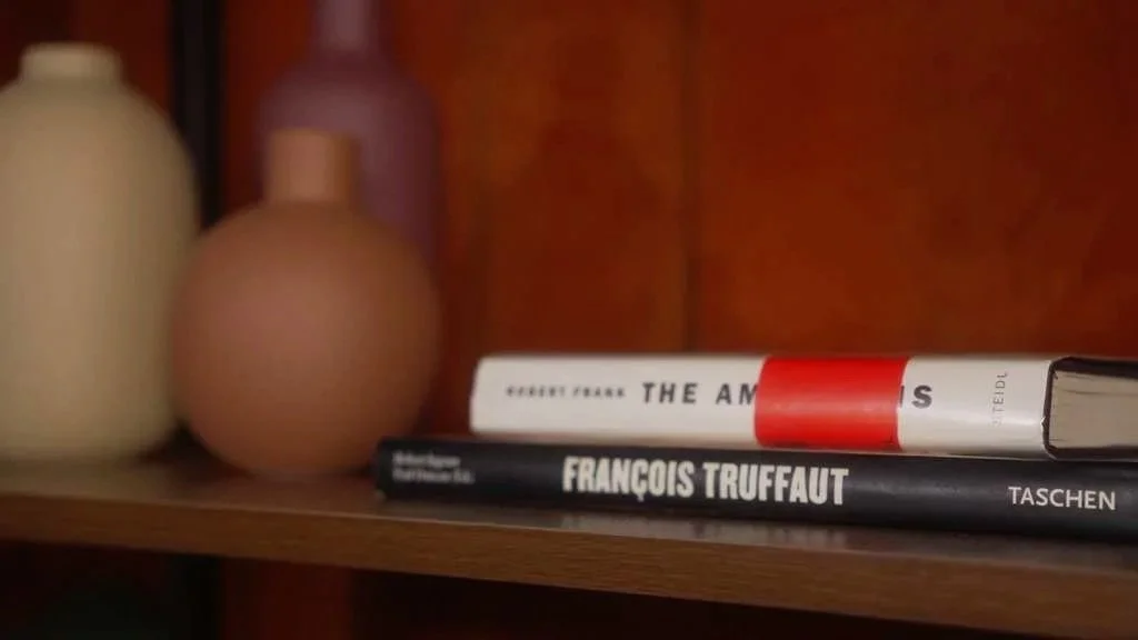 Books and decorative vases on a wooden shelf.