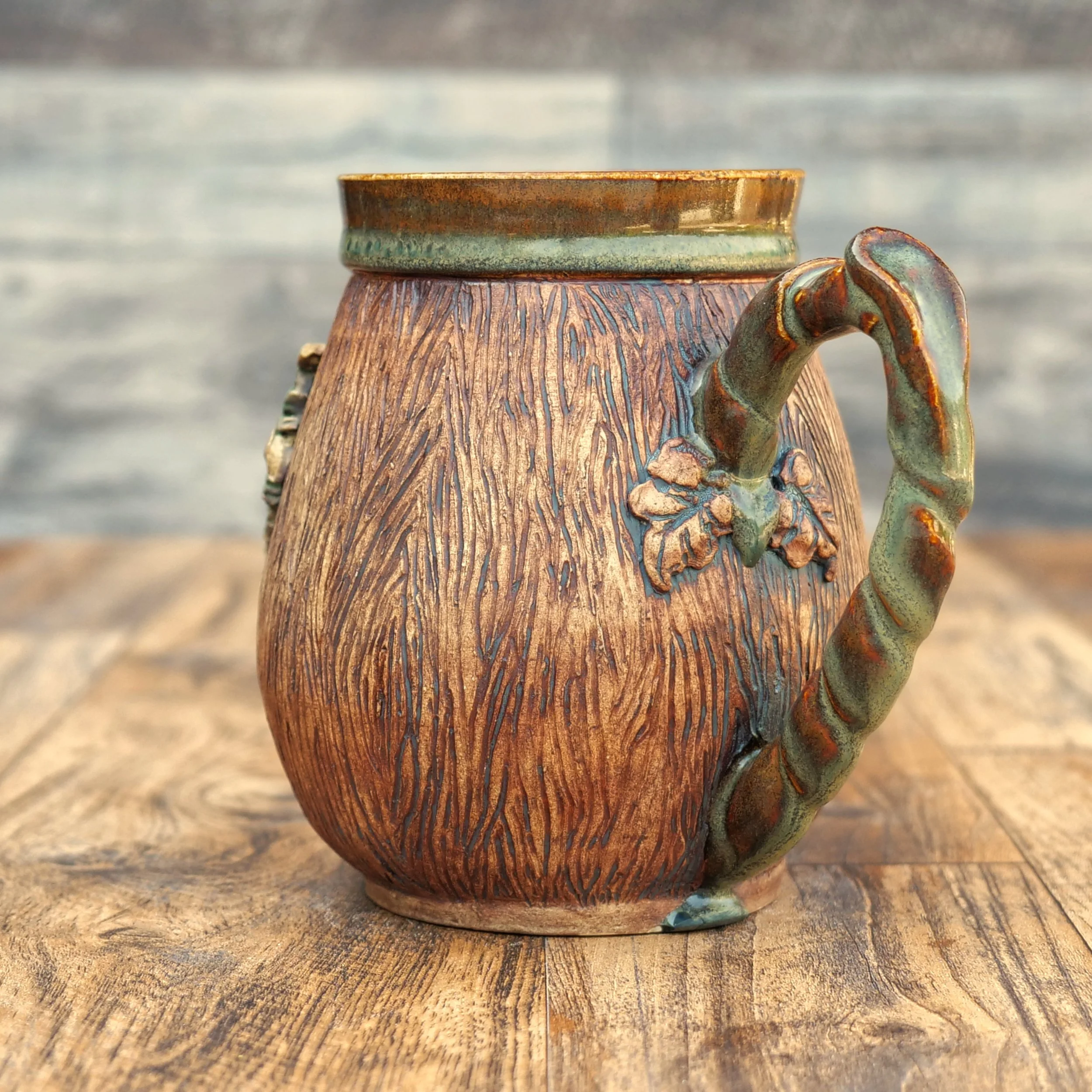 Handmade Woodland Dragon Mug by Elderkiln Ceramics featuring a sculpted forest dragon, carved woodgrain texture, branch-style handle, and earthy woodland glazes.