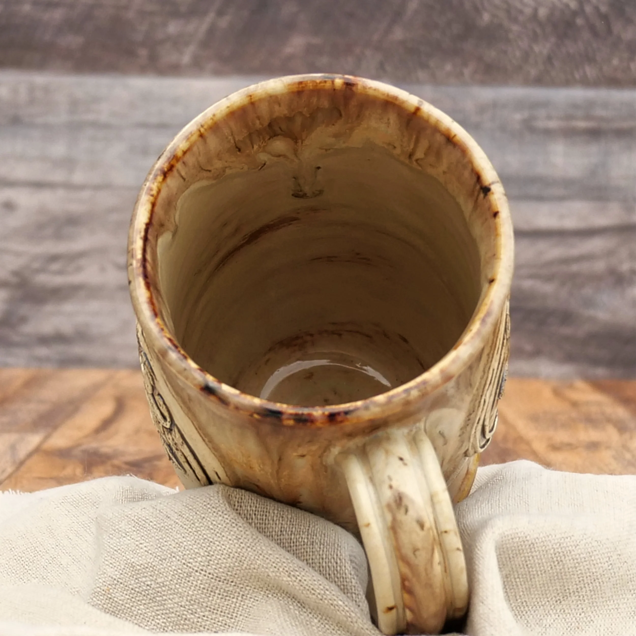 Handmade Celtic Dragon Mug by Elderkiln Ceramics featuring a sculpted dragon and Celtic knot design in warm earthy stoneware glazes.