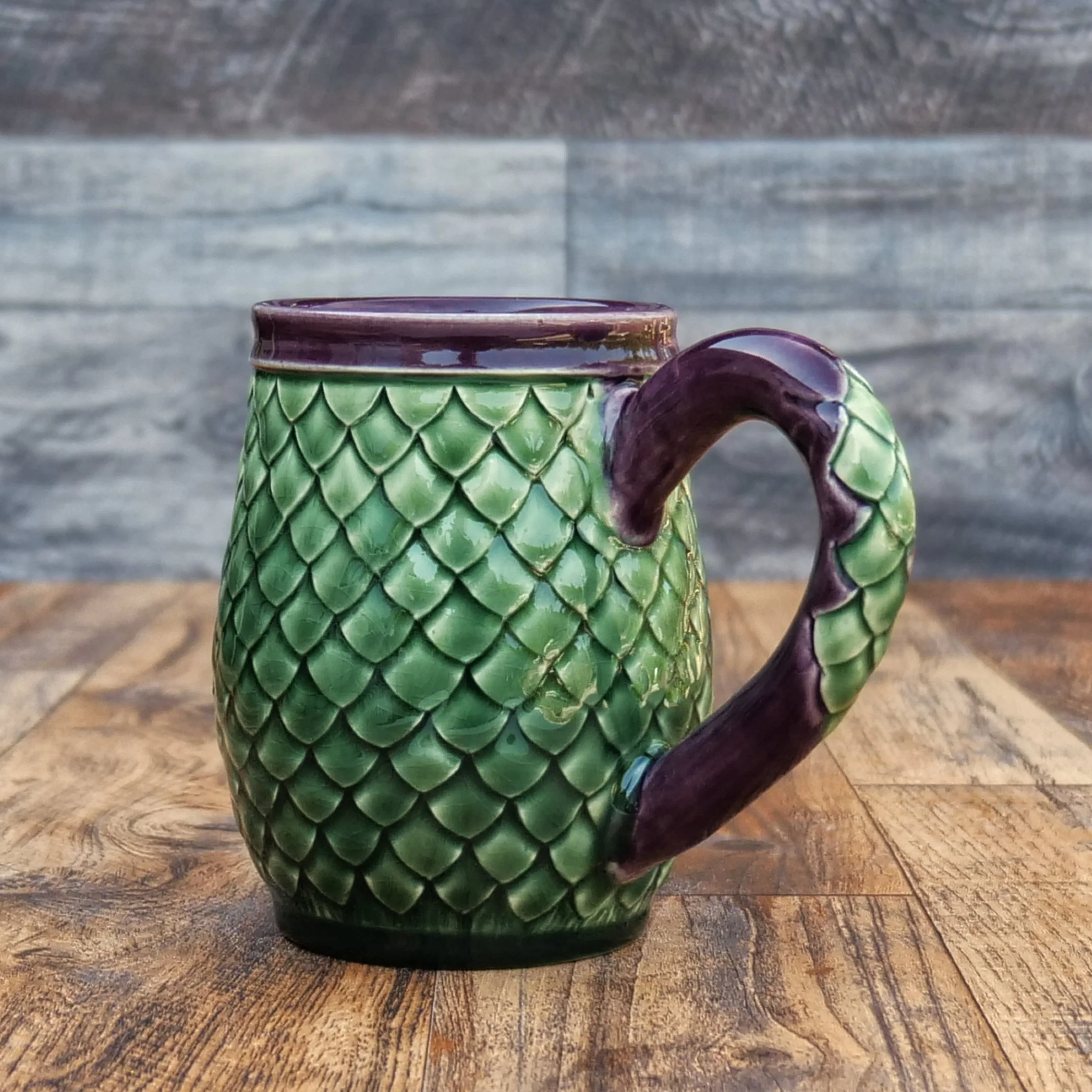 Handmade Emerald Dragon Egg Mug by Elderkiln Ceramics featuring individually sculpted dragon scales and layered emerald green and deep amethyst stoneware glazes.