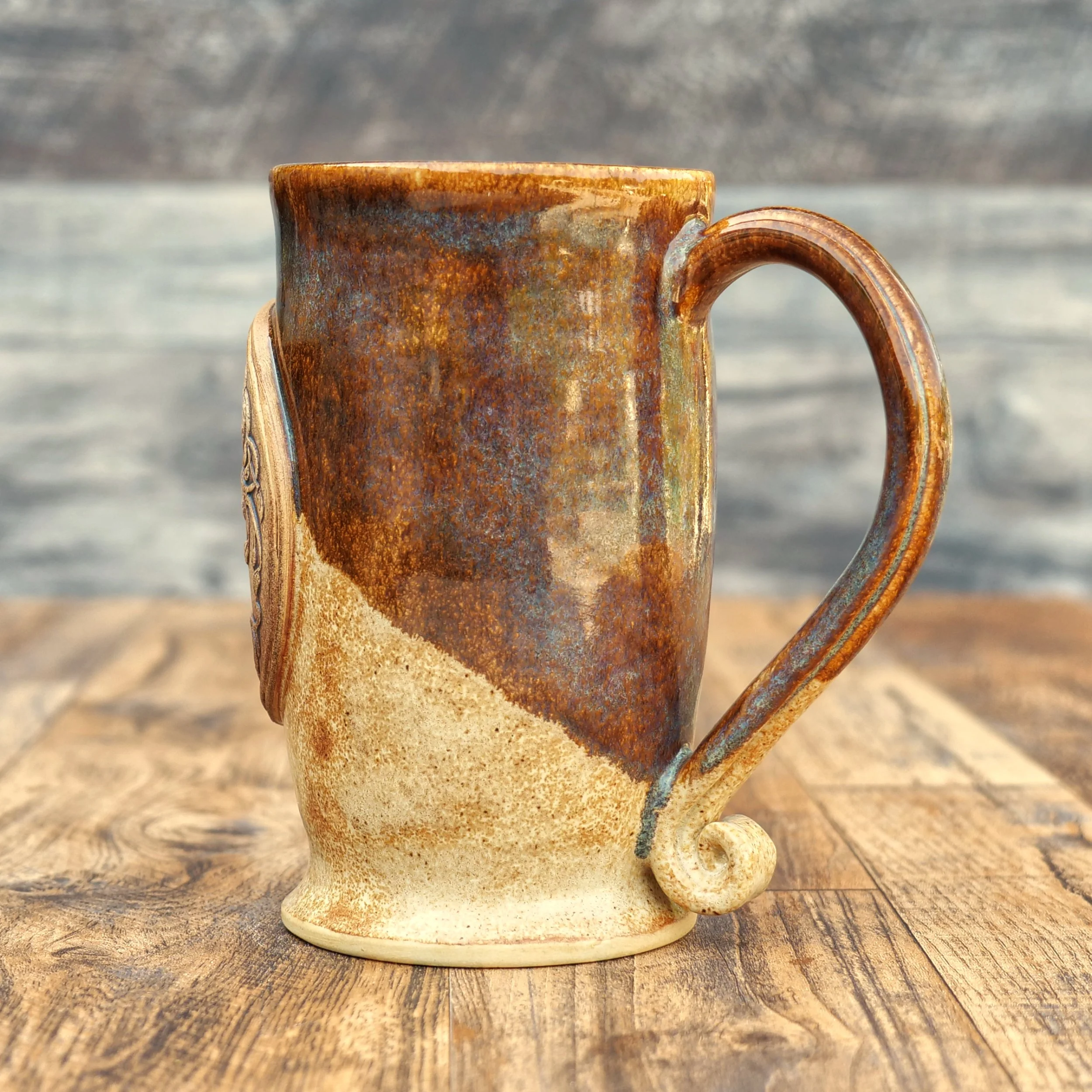 Handmade Tree of Life Mug by Elderkiln Ceramics featuring a sculpted Tree of Life medallion, Celtic-inspired details, and layered earthy stoneware glazes.