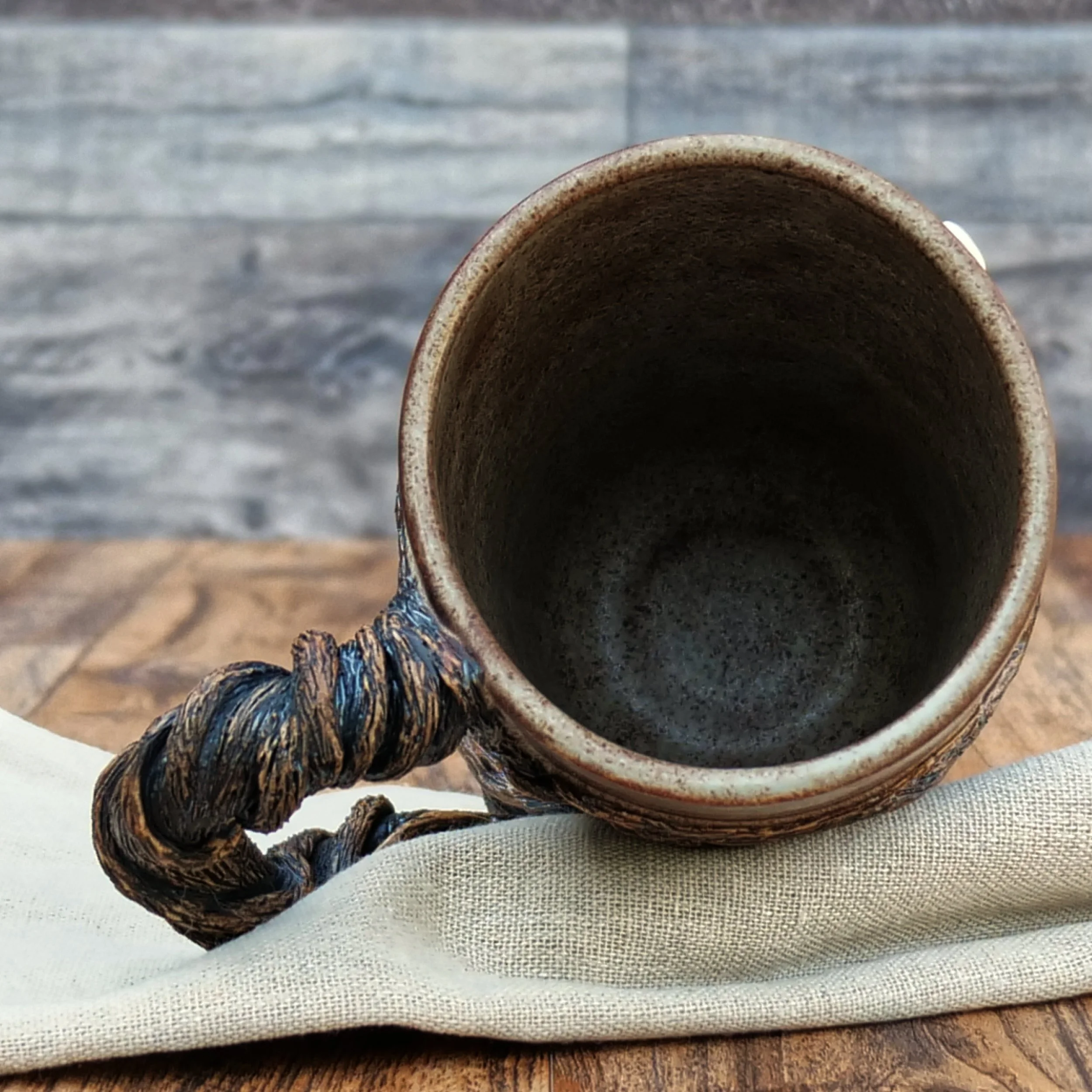 Handmade Moonwatcher Mug by Elderkiln Ceramics featuring a sculpted cat sitting on a tree branch beneath the moon, with wraparound woodland details and a twisted branch handle.