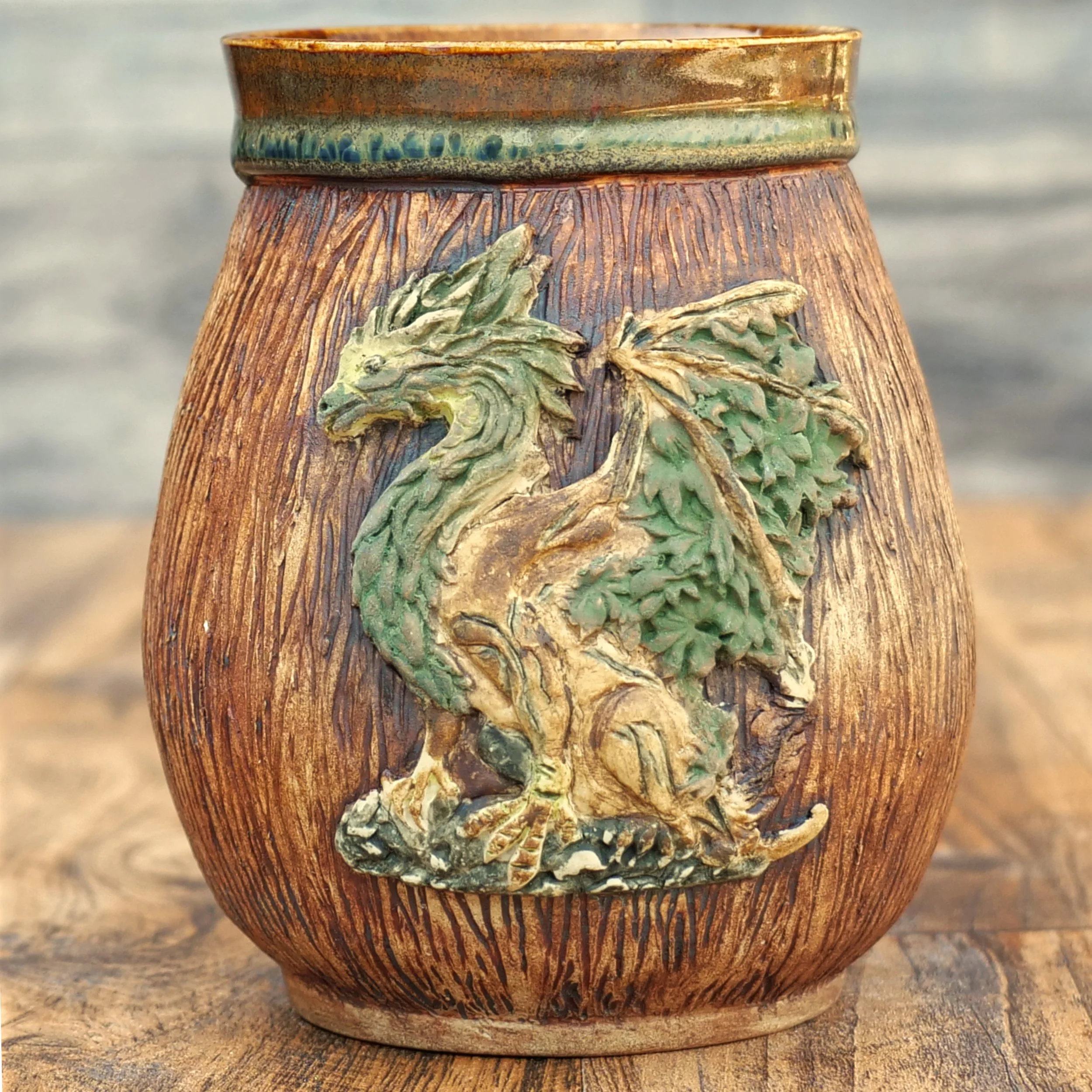 Handmade Woodland Dragon Mug by Elderkiln Ceramics featuring a sculpted forest dragon, carved woodgrain texture, branch-style handle, and earthy woodland glazes.