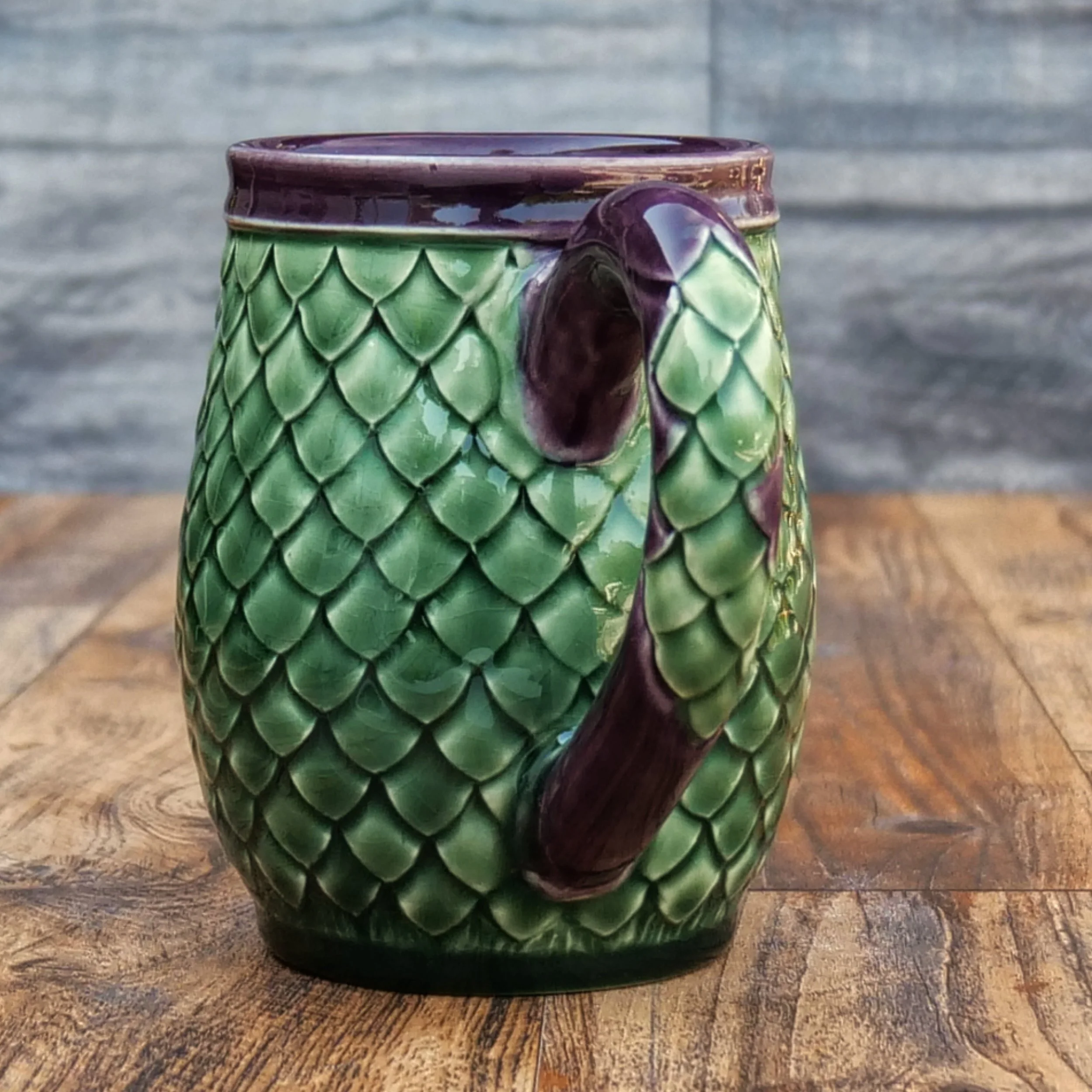 Handmade Emerald Dragon Egg Mug by Elderkiln Ceramics featuring individually sculpted dragon scales and layered emerald green and deep amethyst stoneware glazes.
