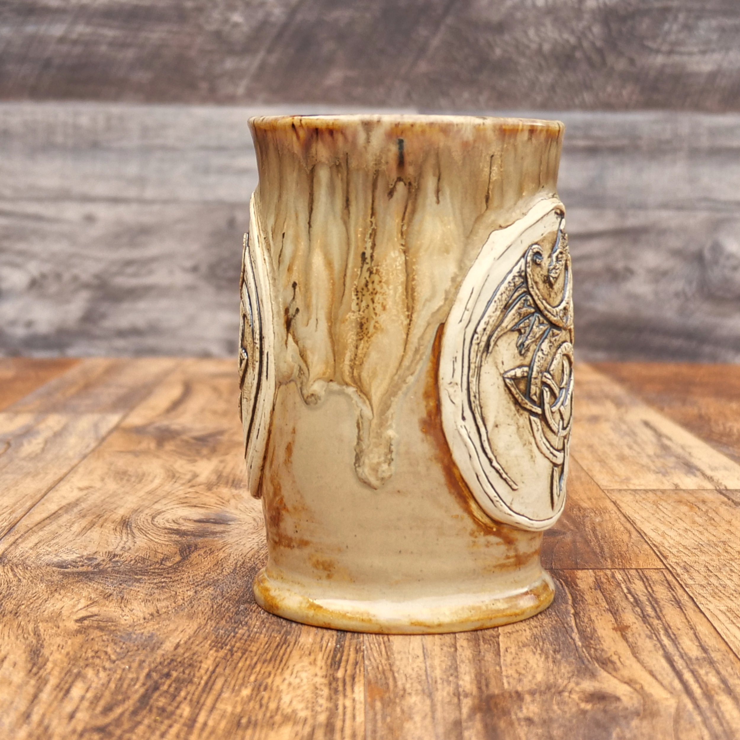 Handmade Celtic Dragon Mug by Elderkiln Ceramics featuring a sculpted dragon and Celtic knot design in warm earthy stoneware glazes.
