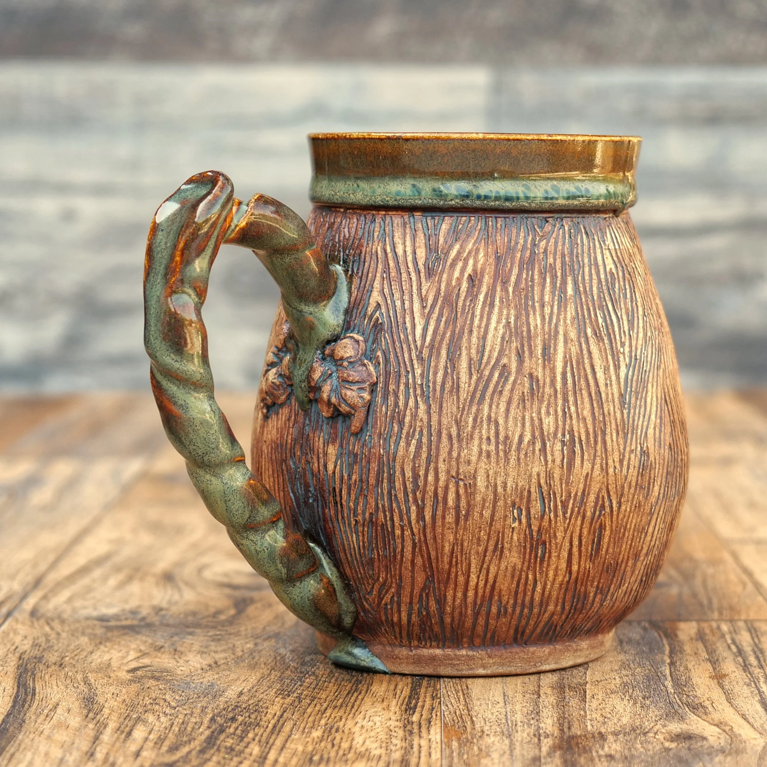 Handmade Woodland Dragon Mug by Elderkiln Ceramics featuring a sculpted forest dragon, carved woodgrain texture, branch-style handle, and earthy woodland glazes.