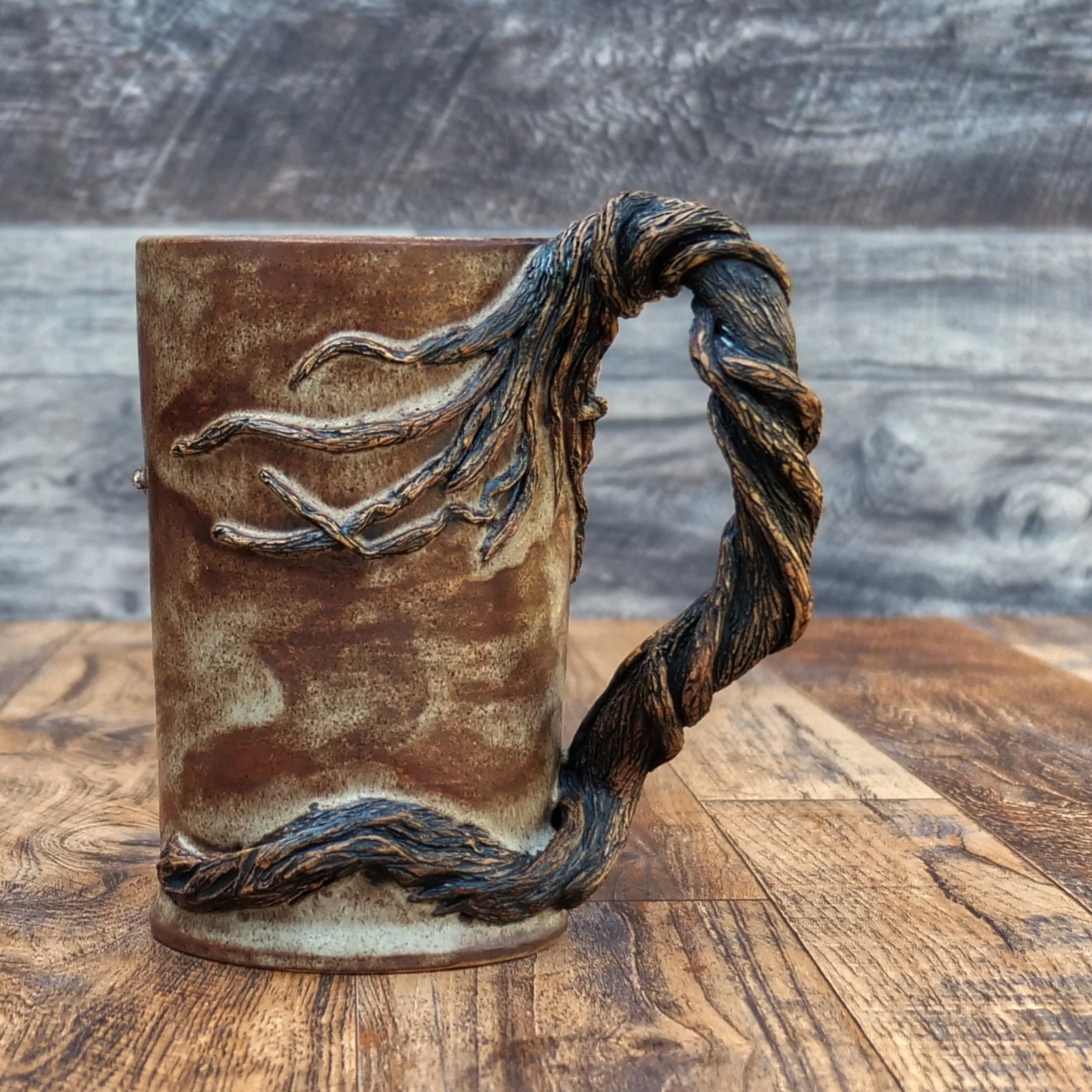 Handmade Moonwatcher Mug by Elderkiln Ceramics featuring a sculpted cat sitting on a tree branch beneath the moon, with wraparound woodland details and a twisted branch handle.