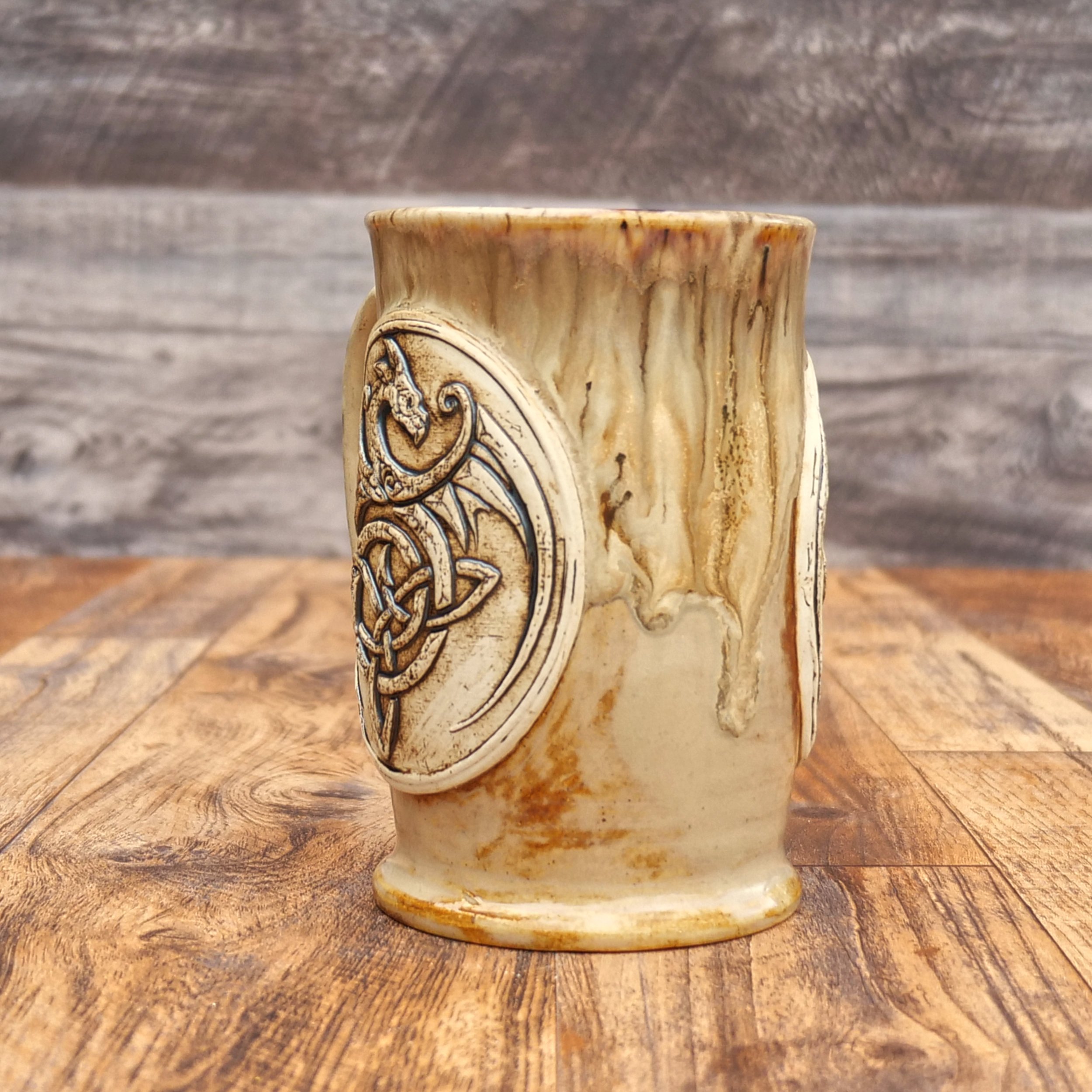 Handmade Celtic Dragon Mug by Elderkiln Ceramics featuring a sculpted dragon and Celtic knot design in warm earthy stoneware glazes.