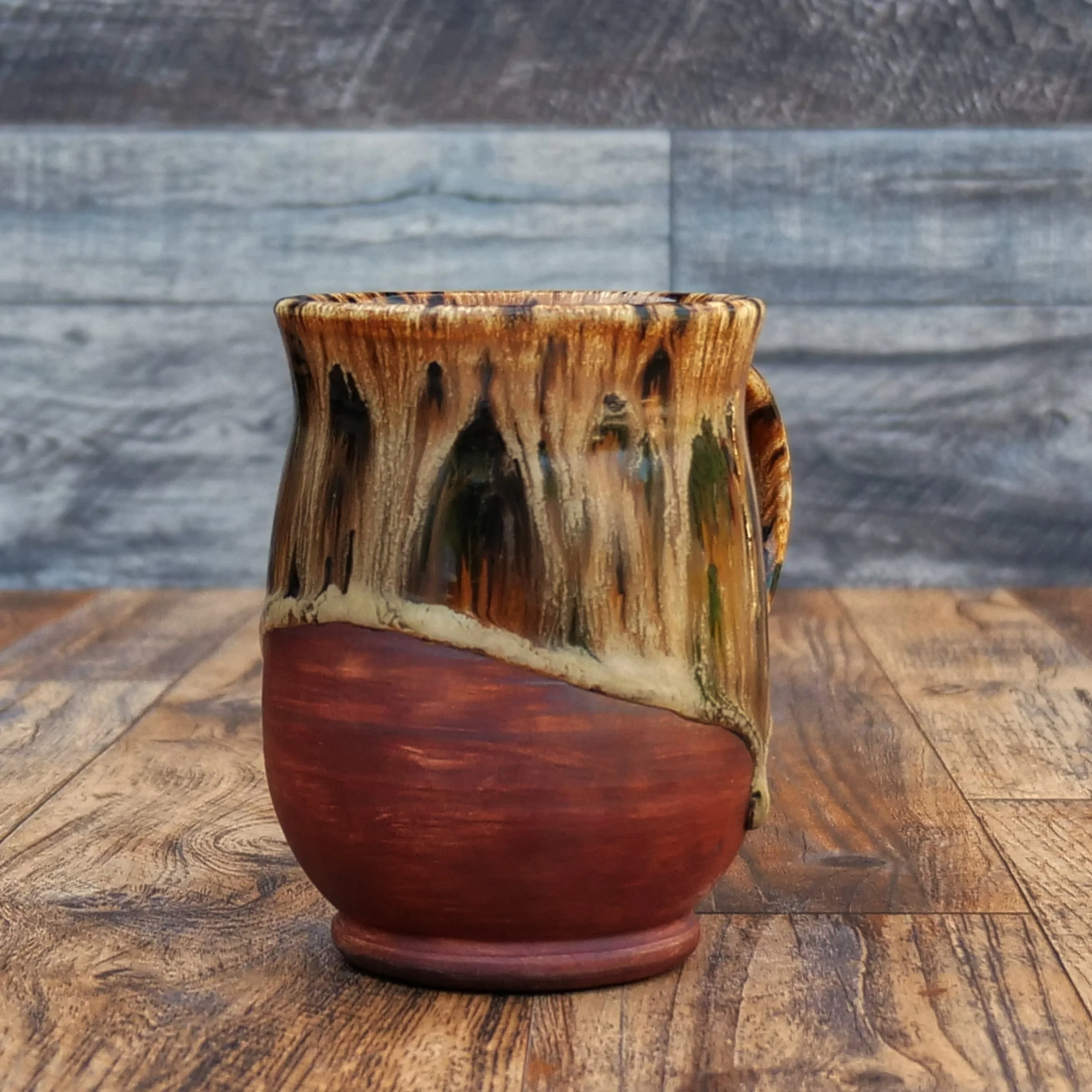 Handmade Emberbark Mug by Elderkiln Ceramics featuring layered bark-inspired glazes, flowing earthy tones, and a warm iron-red stoneware base.