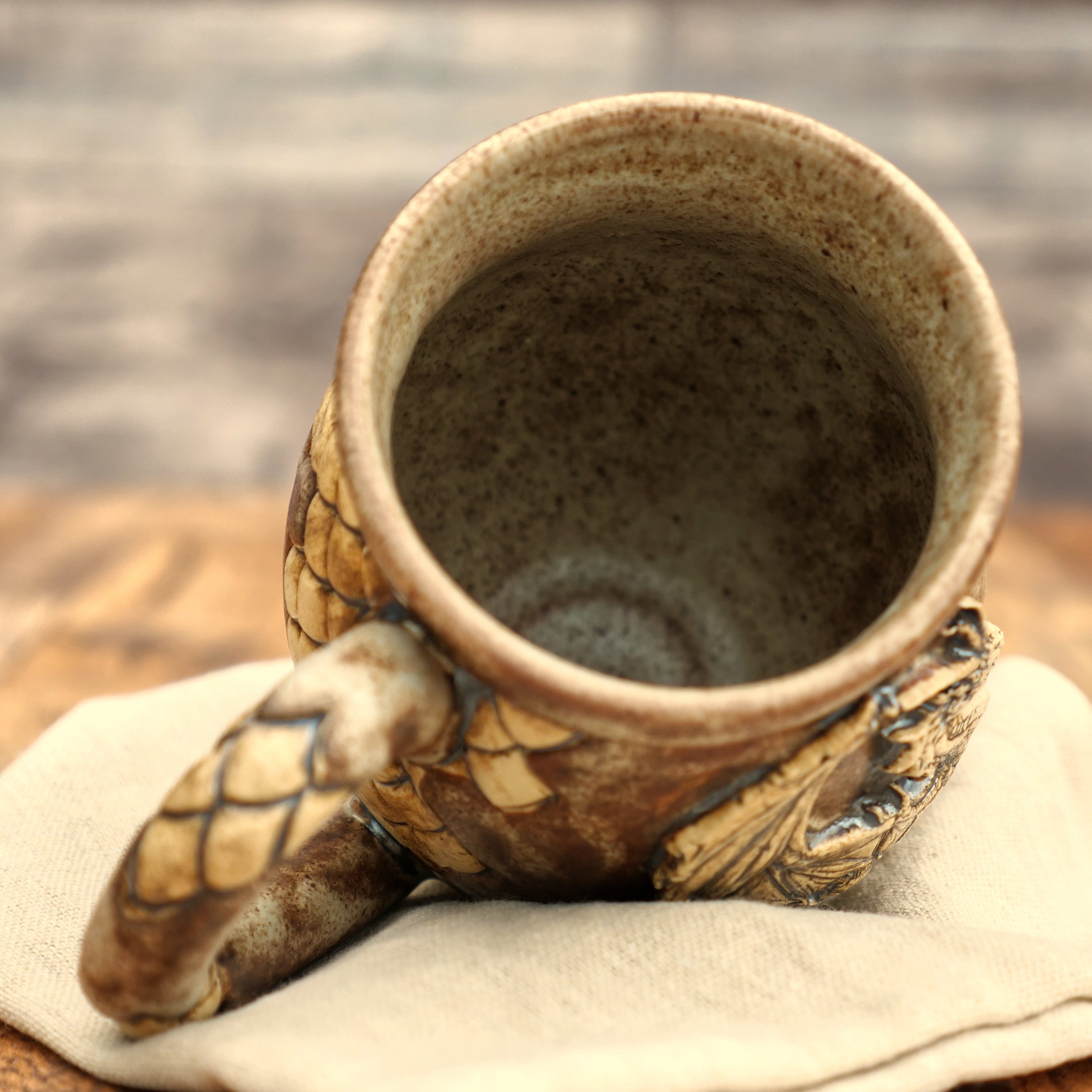 Handmade stoneware dragon mug by Elderkiln Ceramics with earthy glaze and sculpted handle detail.