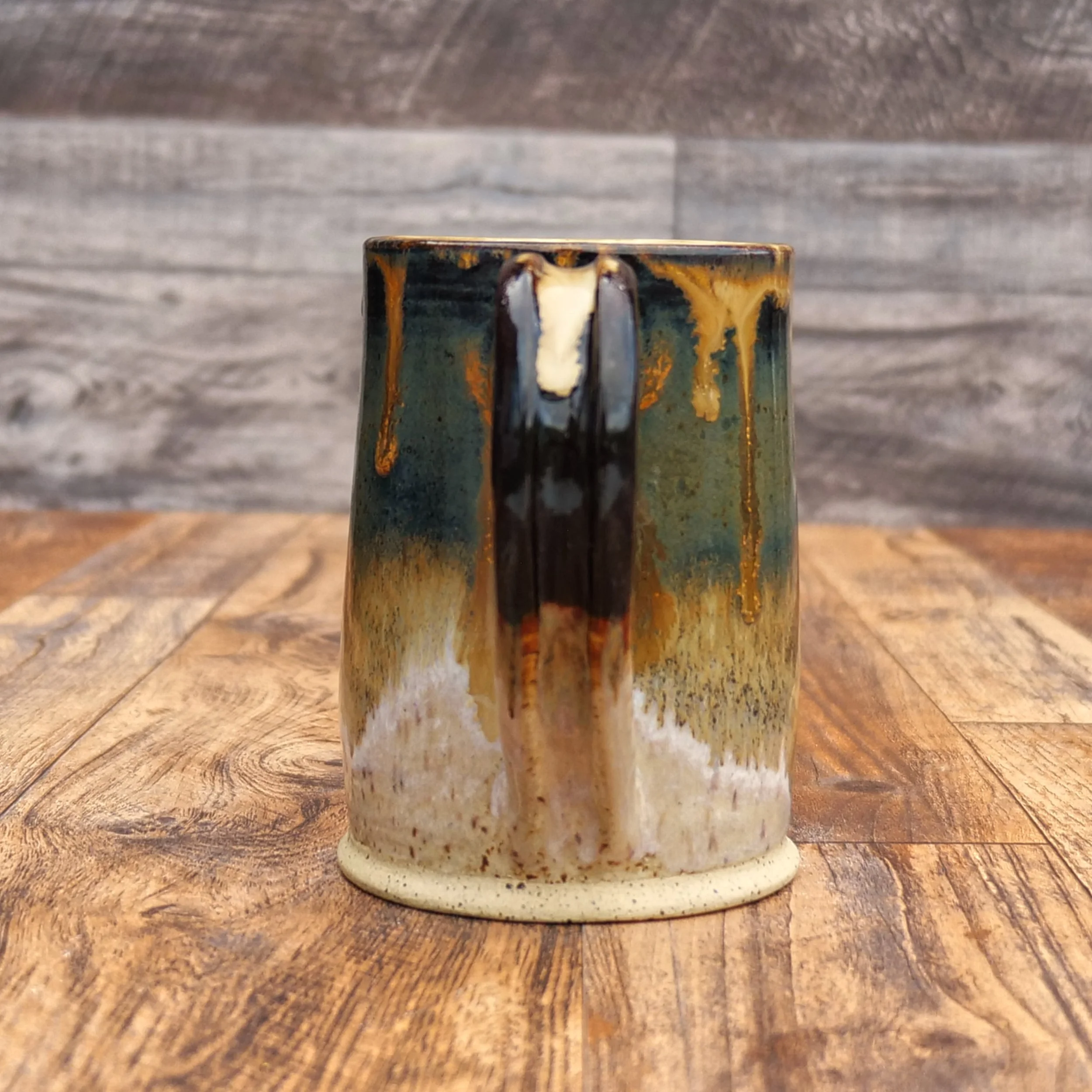 Handmade Amberfall Mug by Elderkiln Ceramics featuring layered amber, bronze, and forest-toned stoneware glazes with flowing natural glaze effects.