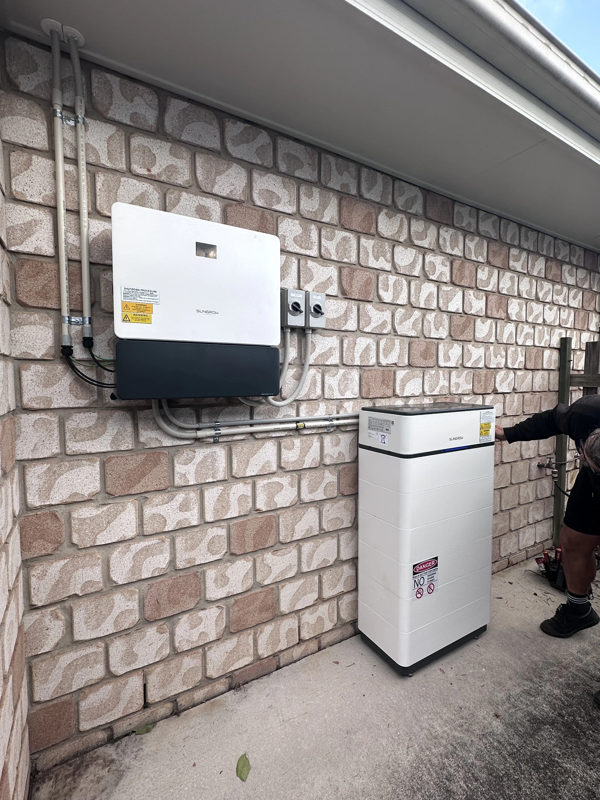 A Sungrow Battery storage system and a Sungrow Inverter installed on a brick house in Thornlands, Queensland.
