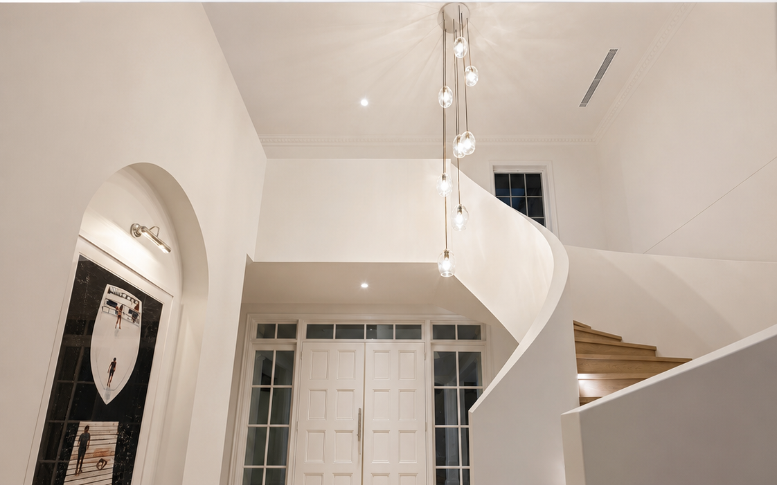 Chandelier lighting installed over staircase in luxury home
