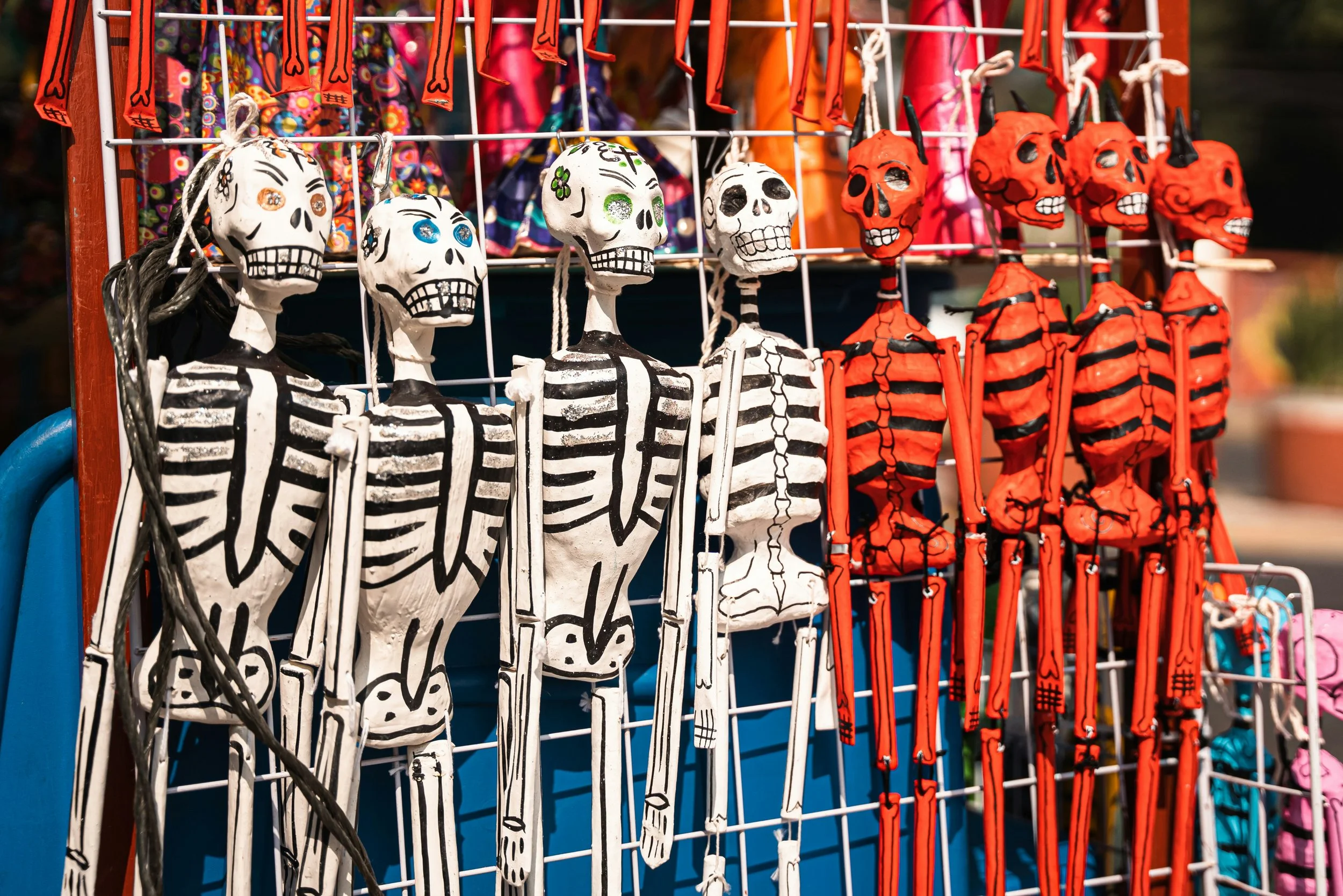 Display of decorative skeletons and skulls for sale on a street vendor stand in Mexico City.