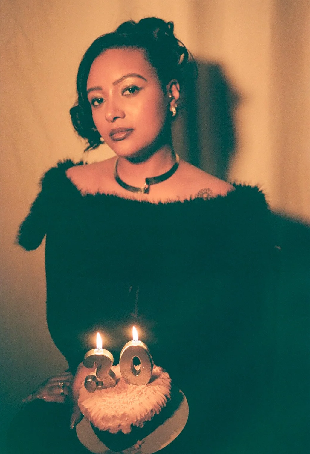 Woman celebrating her 20th birthday with a cake that has candles shaped as the number 20.