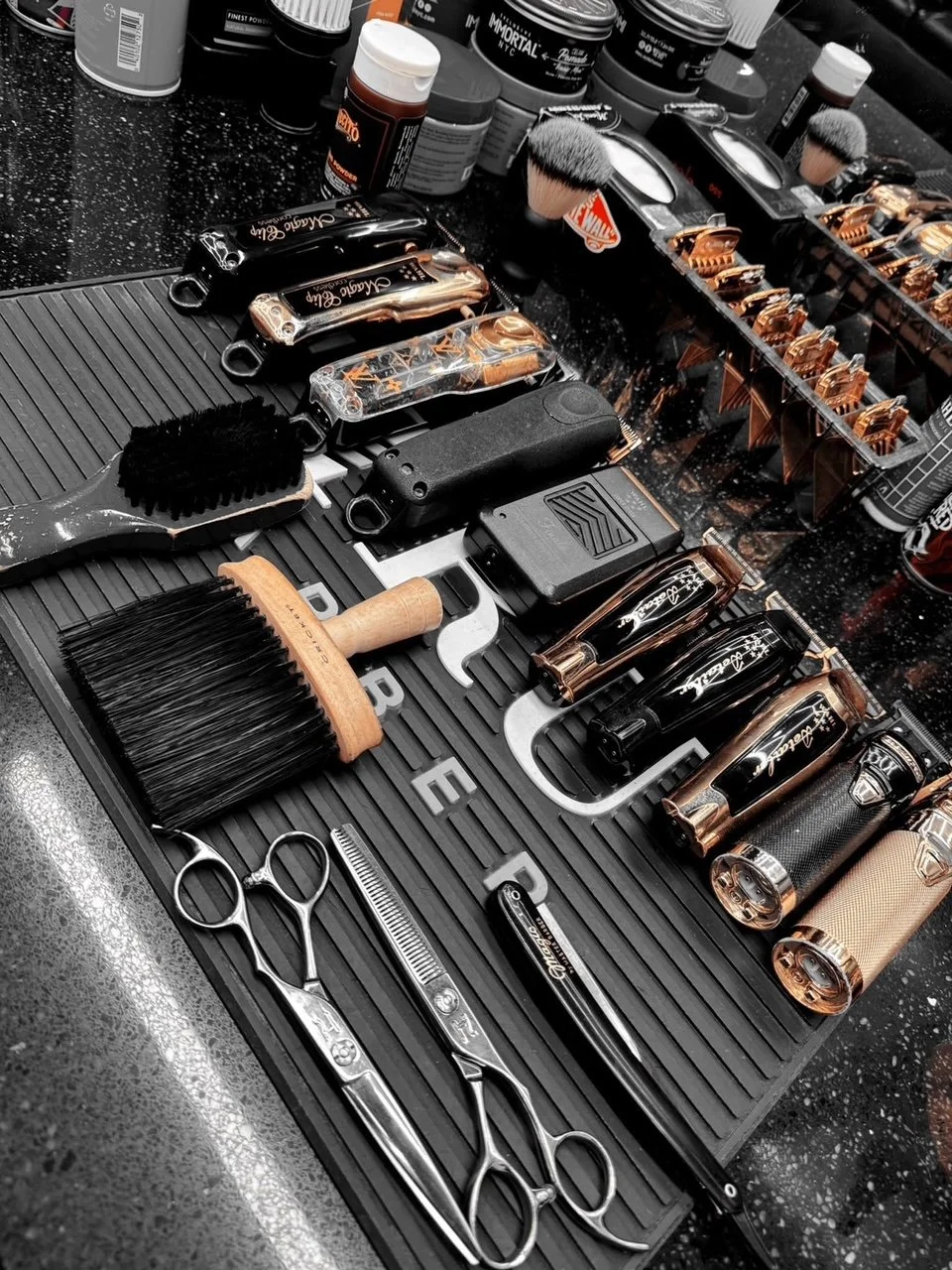 Classic Barbershop barber Rick's work station with grooming tools like scissors, clippers, brushes, and bottles of grooming products.