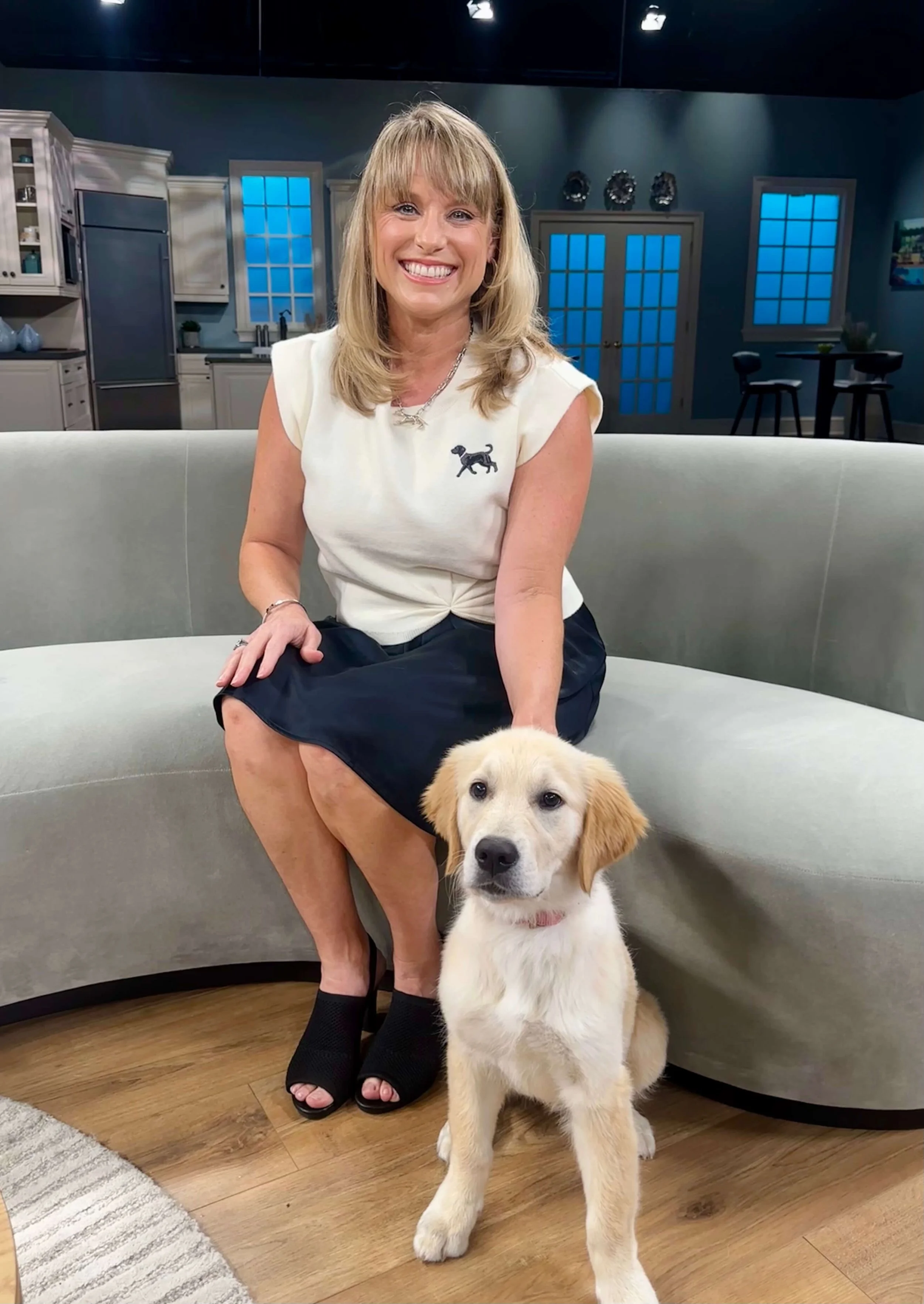 Kelly Diedring with a dog on a tv set