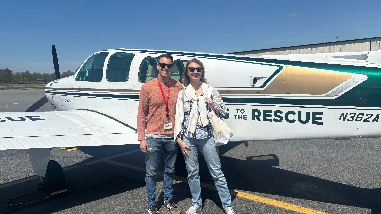 Patricia Jones in front of Pilots to the rescue airplane with the founder
