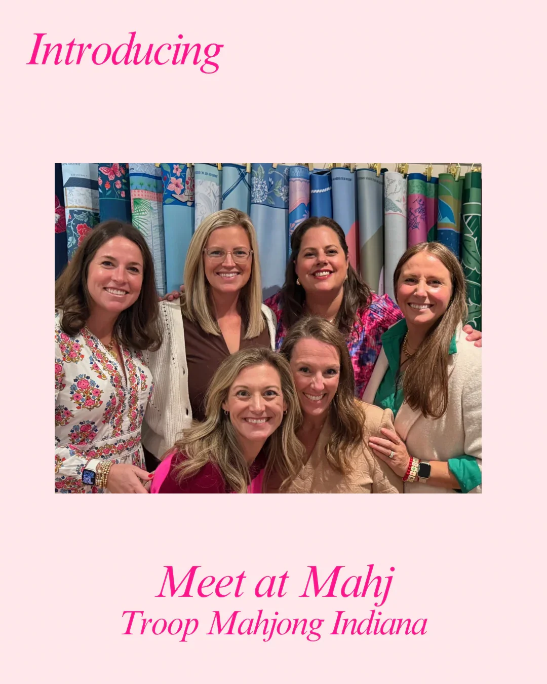 Group of six women smiling at a photo in front of a colorful curtain, with pink text on a light pink background that says "Introducing" at the top and "Meet at Mahj Troop Mahjong Indiana" at the bottom.